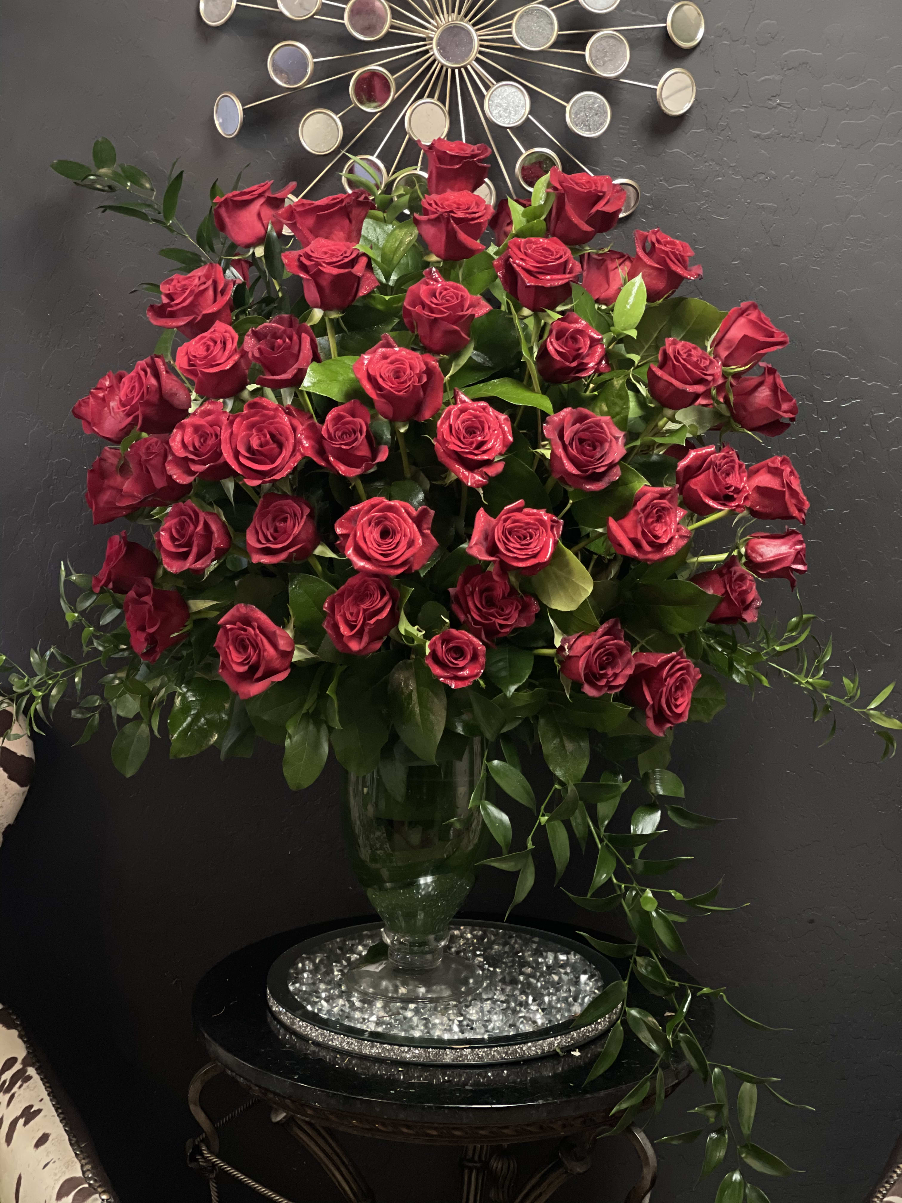 Attraction Luxury 100 Rose Bouquet - 24-inch Premium Long-Stemmed Roses - VASE INCLUDED - Love is in the air and pounding in your heart. Bind your hearts as one with an overwhelming and dazzling display of our 24-inch premium long-stemmed rich red roses situated in a highly elegant clear glass pedestal vase. This timeless display of beauty extends the traditions of ages past to link your hearts to the future.  Includes of 24-inch premium long-stemmed red roses, exotic foliage and a superior 16-inch clear glass pedestal vase. Approx. 33H x 26W Your purchase includes a complimentary personalized gift message.