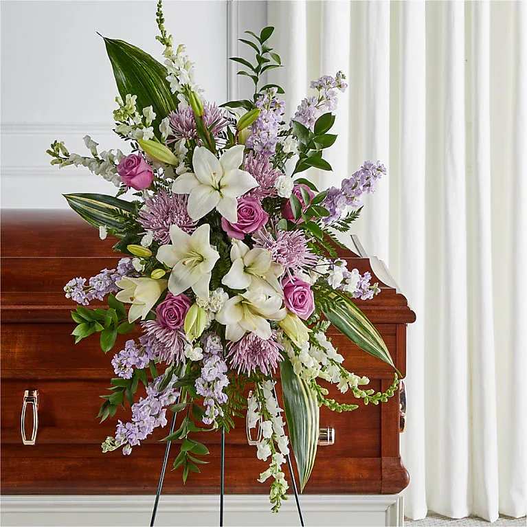 Standing floral spray with white lilies, pink roses, and lavender blooms