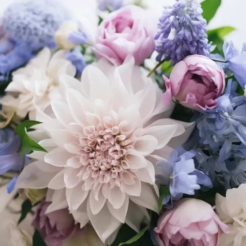 Cool Tones - Floral arrangement of seasonal blooms in Cool Tones arranged in a vase. PLEASE NOTE: Flower stems and colors will vary due to availability. Designer's Choice will contain seasonal flowers! 