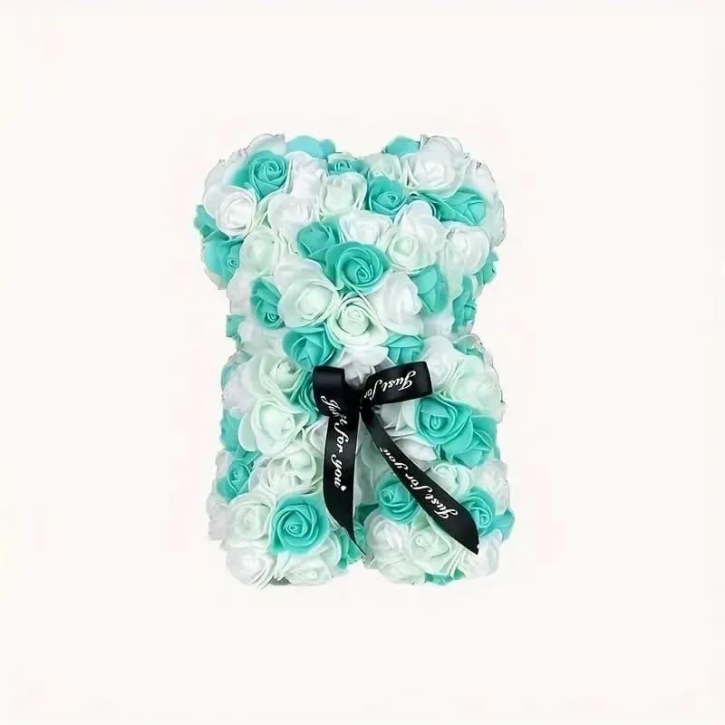 Diva Bear - A whimsical teddy bear-shaped floral arrangement crafted from tightly packed turquoise and white roses makes an unforgettable gift set for birthdays, anniversaries, or romantic gestures. This flower arrangement presents a playful silhouette and high-contrast pattern that will make the person you're thinking of smile the moment it arrives.  Made from silk roses in mixed turquoise (blue) and white hues, the compact design highlights the texture of each bloom and keeps the bear looking neat and decorative on display. A black ribbon tied at the center gives a polished, gift-ready finish and a slightly formal touch, perfect for placing on a mantle, desk, or bedside table.  Choose this arrangement when you want a keepsake that looks fresh forever and reads as both whimsical and thoughtful-ideal for celebrating special moments or sending affection that lasts. Free delivery ensures it arrives ready to delight.