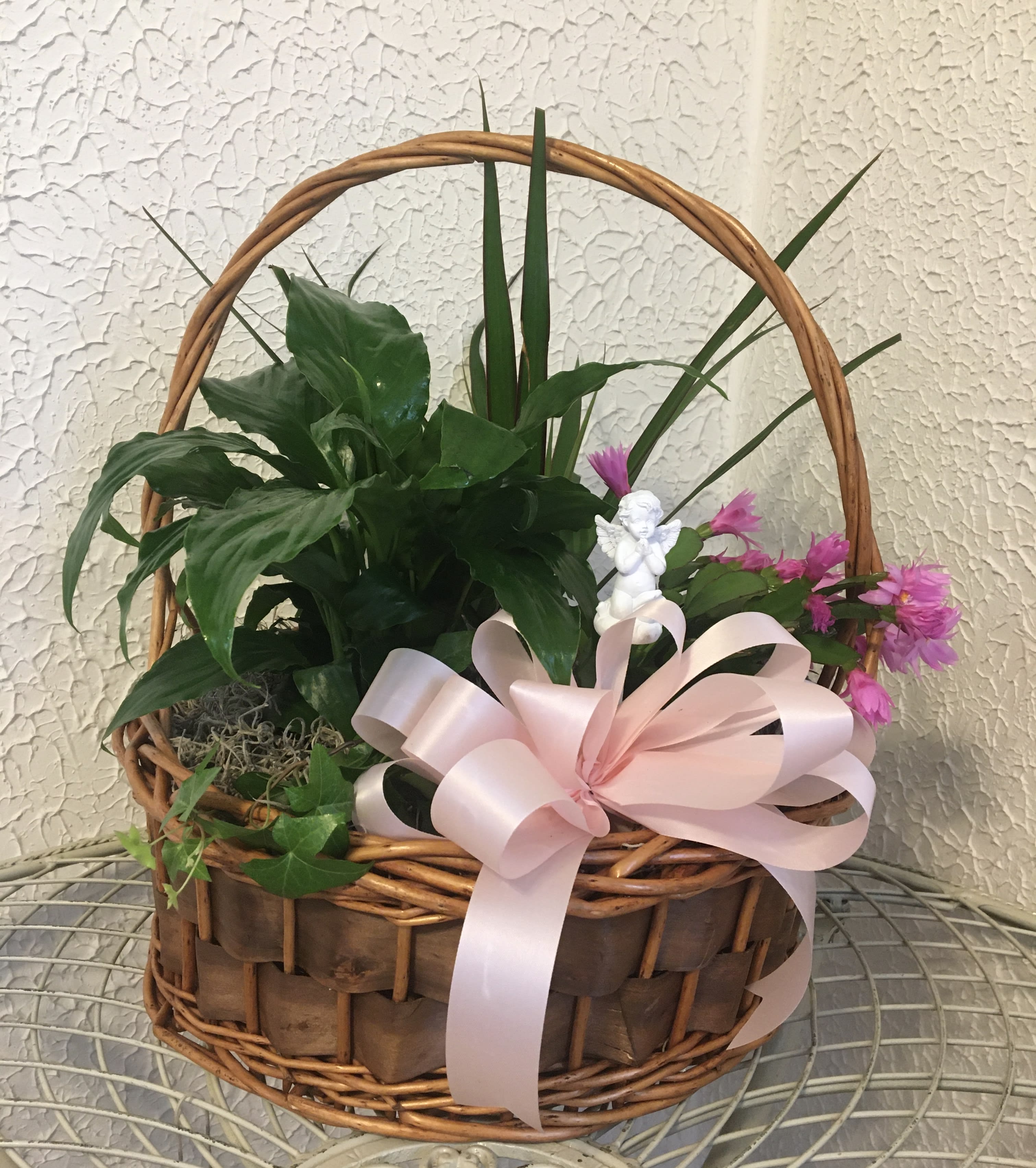 Potted plant basket with pink flowers, a ribbon, and a small angel figurine