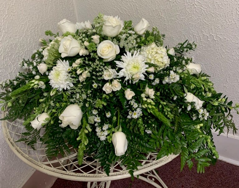 White roses and chrysanthemums arranged in a low, lush spray