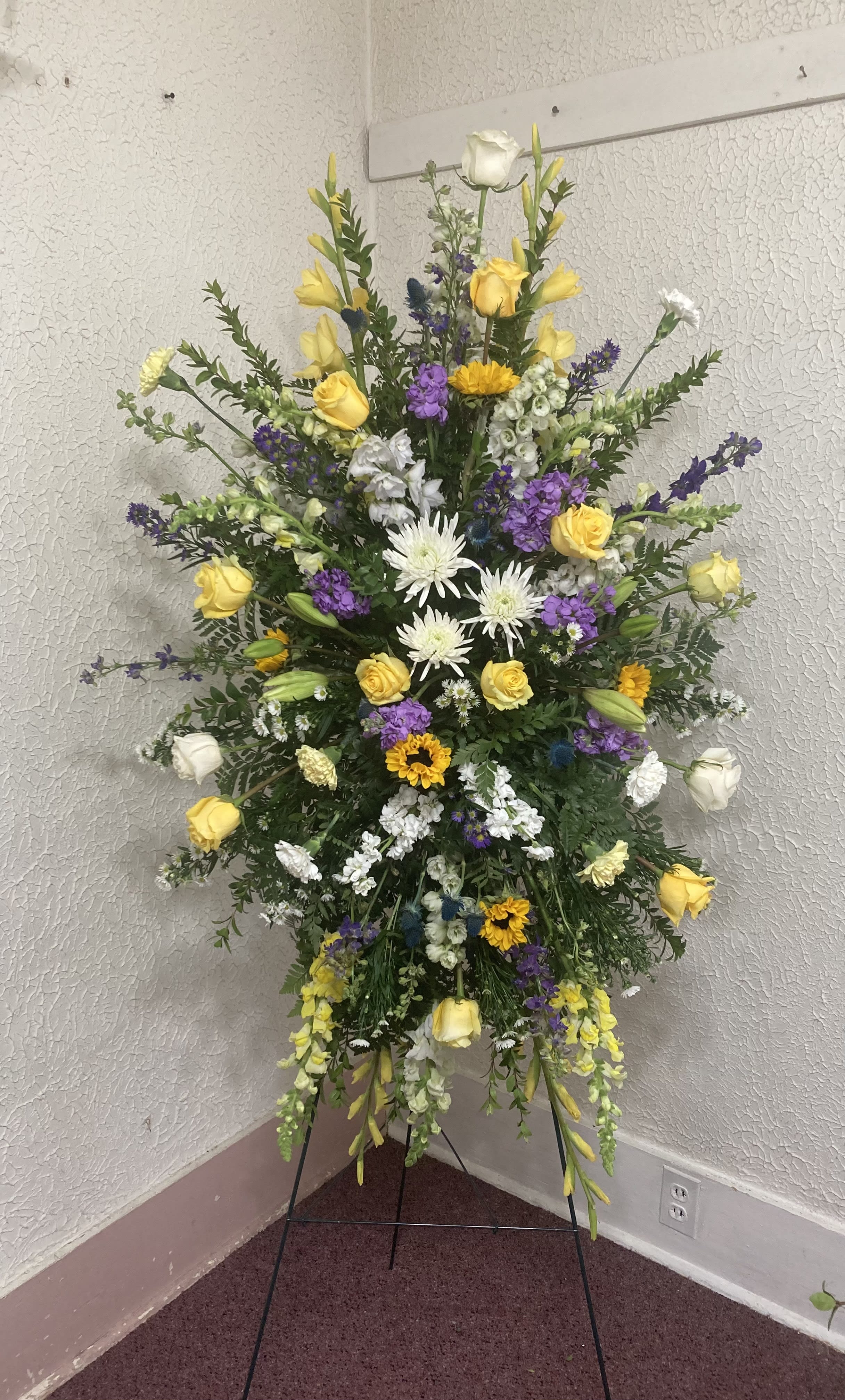 Tall standing floral spray with yellow, white, and purple flowers