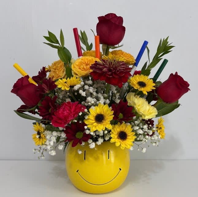 Mixed bouquet in a yellow smiley-face vase with red roses and yellow daisies