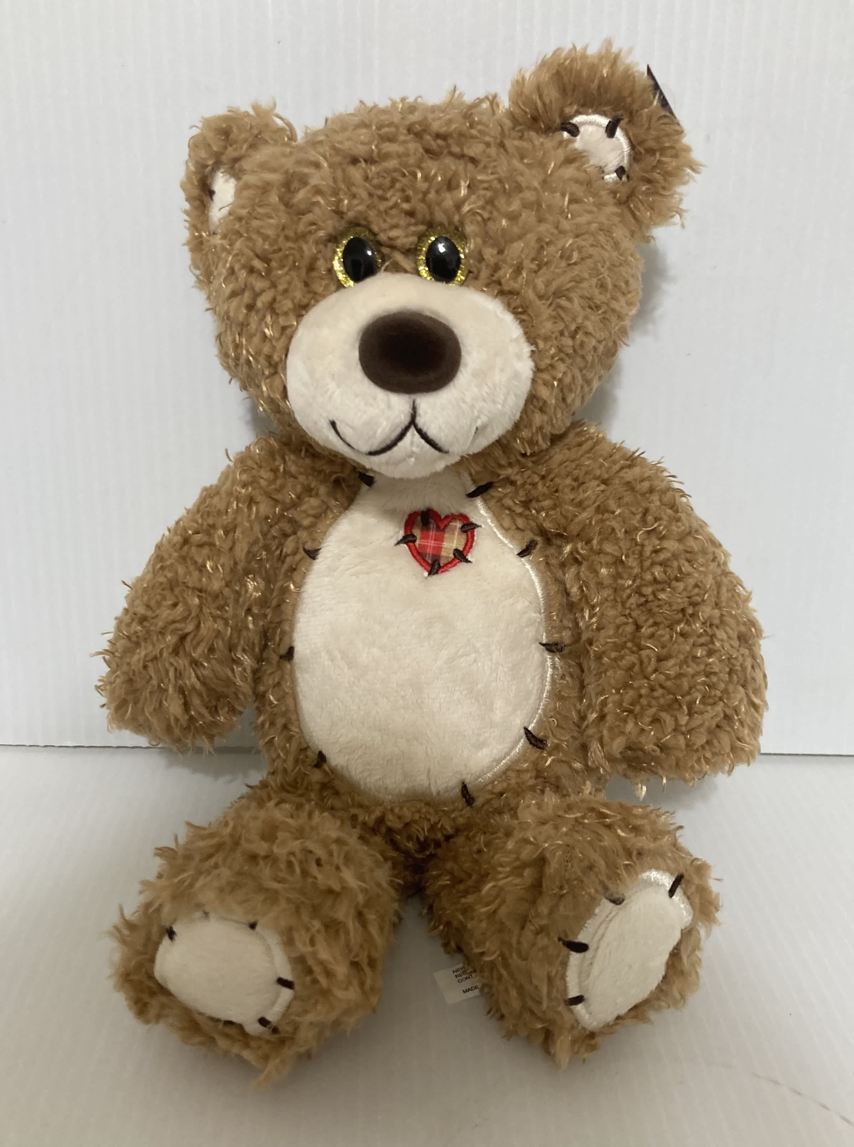 Brown teddy bear plush with a cream belly and heart patch