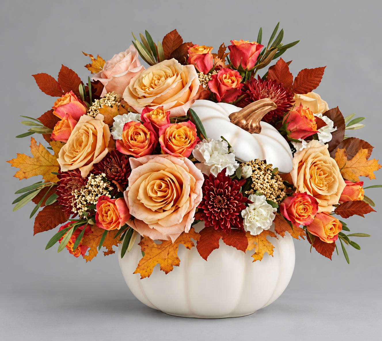 Autumn floral arrangement in a white pumpkin vase with peach and orange roses