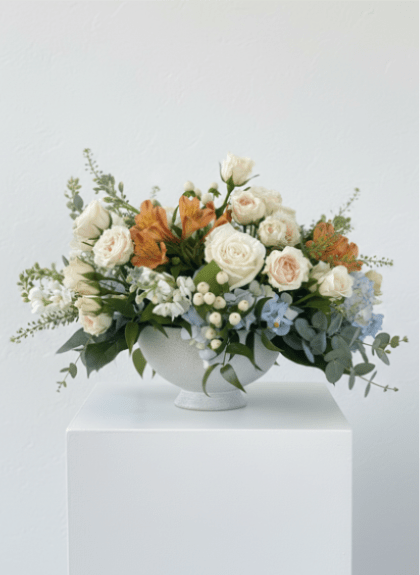 Exquisite Taste   - Elevate Your Space with Timeless Elegance Introducing "Exquisite Taste," a sophisticated arrangement set in a classic ceramic white compote, brimming with a variety of soft-colored blooms. This elegant display is perfect for enhancing any entry table, centerpiece, or bedside table, adding a touch of refined beauty to your home. **Soft Color Blooms: A harmonious blend of pastel hues creates a serene and inviting atmosphere, ideal for any setting. **Ceramic White Compote: The timeless design of the compote complements the delicate flowers, offering a chic and versatile decorative piece. **Versatile: Whether used as a welcoming entryway piece, a stunning centerpiece, or a gentle bedside accent, this arrangement adds elegance and charm to any room. Choose "Exquisite Taste" from Elizabeth's Garden to bring a touch of sophistication and grace to your space, perfect for those who appreciate refined beauty and exquisite design. 