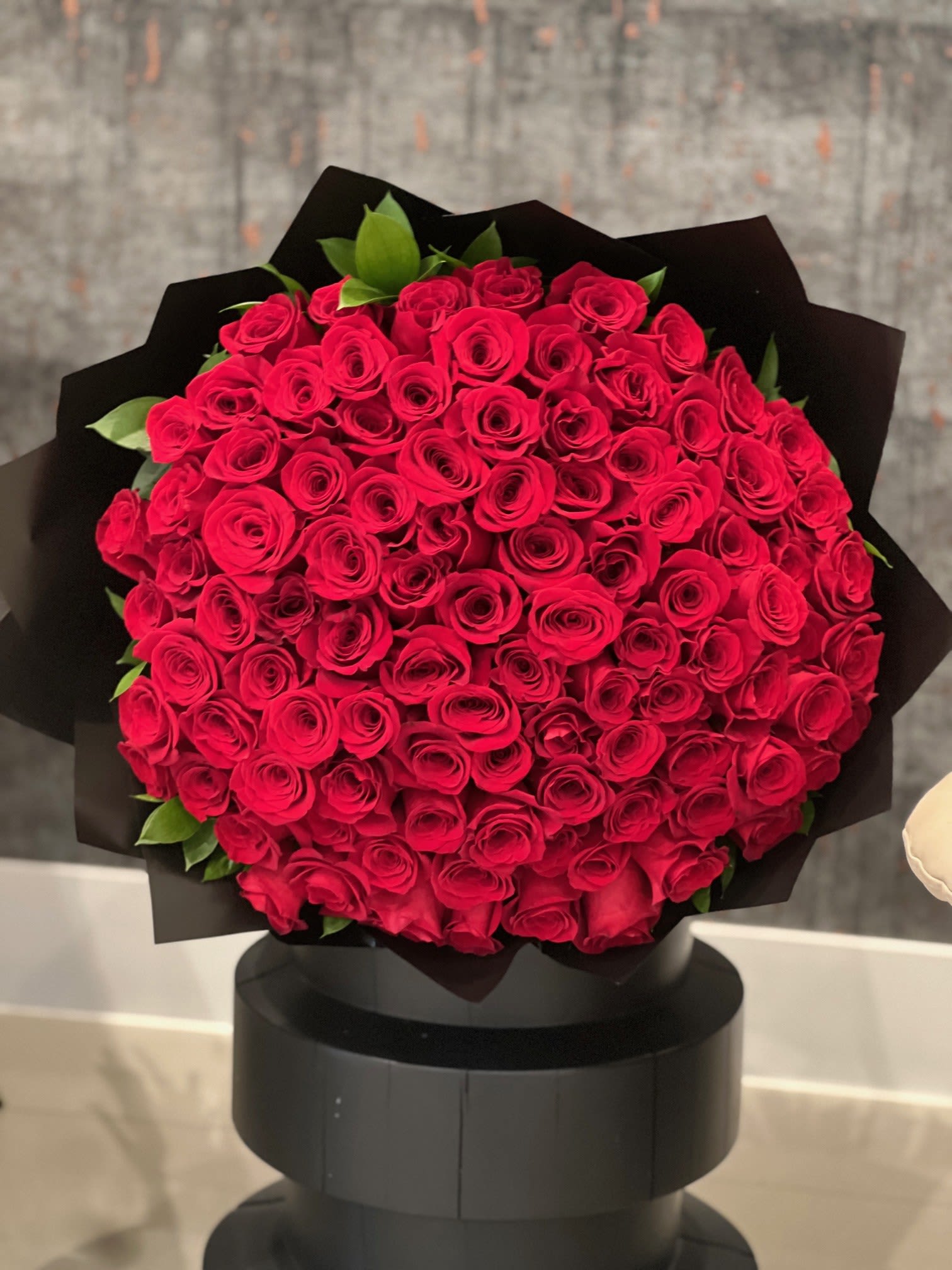 Large bouquet of red roses wrapped in black paper