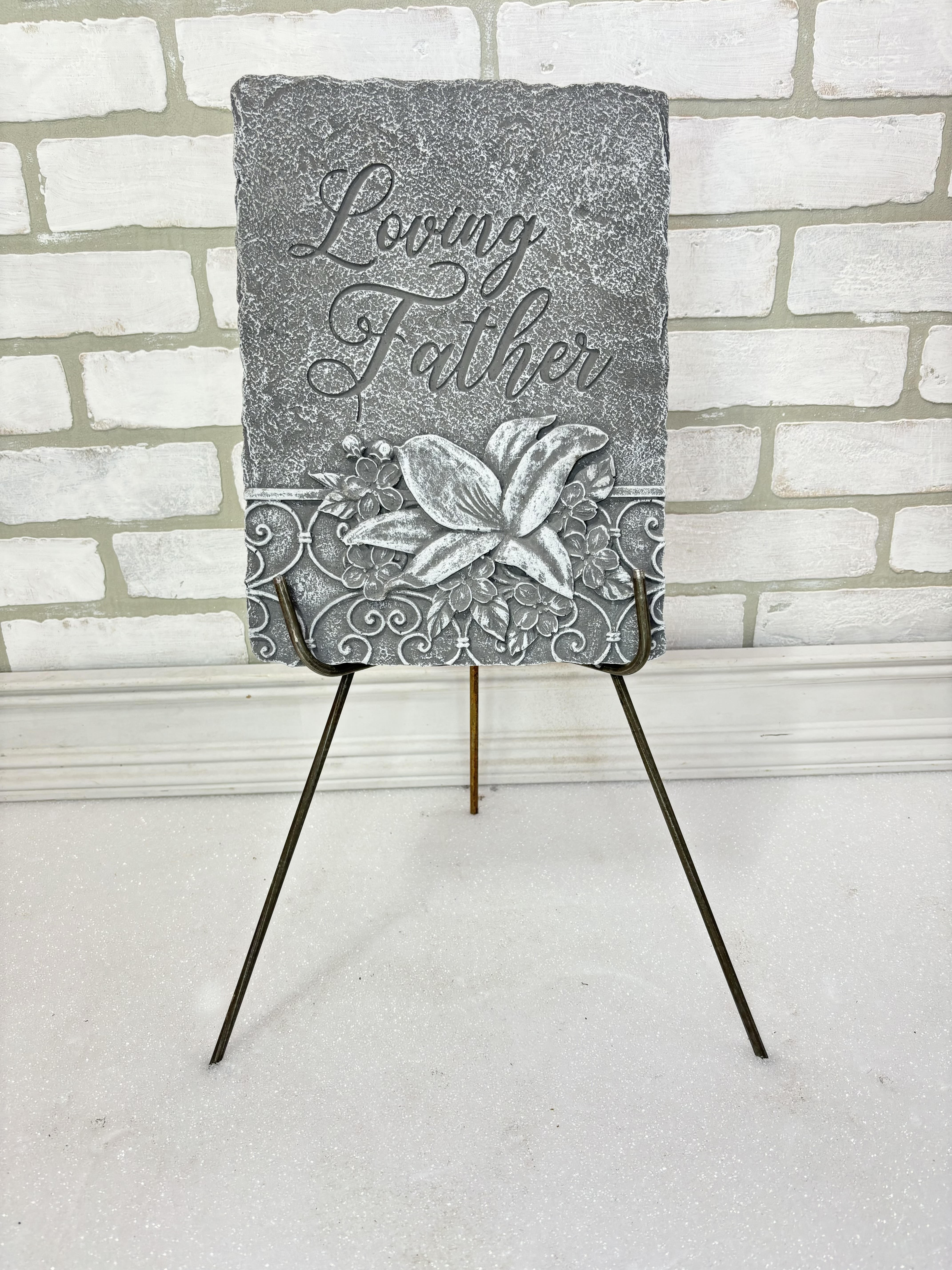 Gray memorial plaque on a metal easel with the words Loving Father