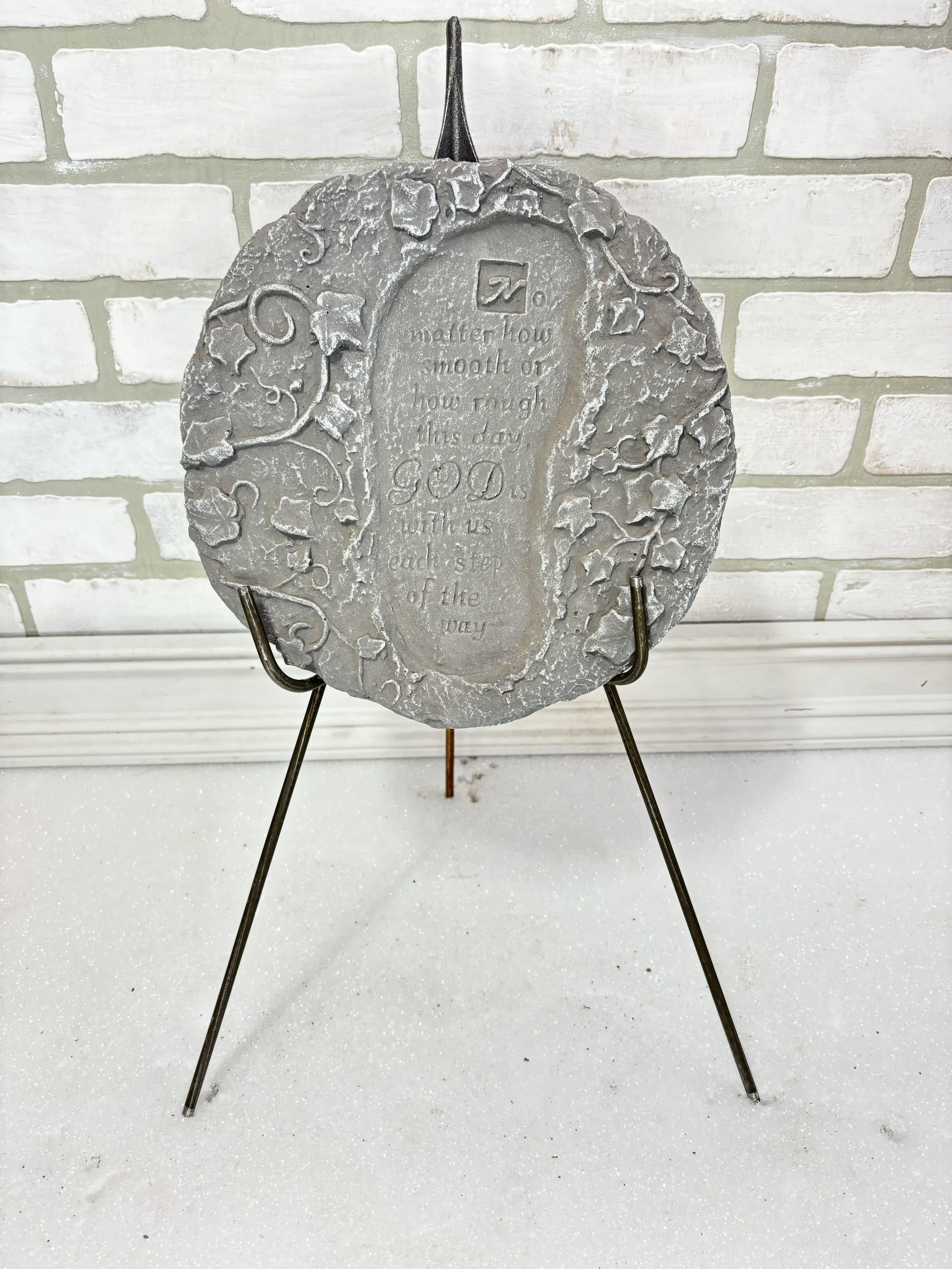 Gray decorative plaque on a metal stand with an inspirational quote