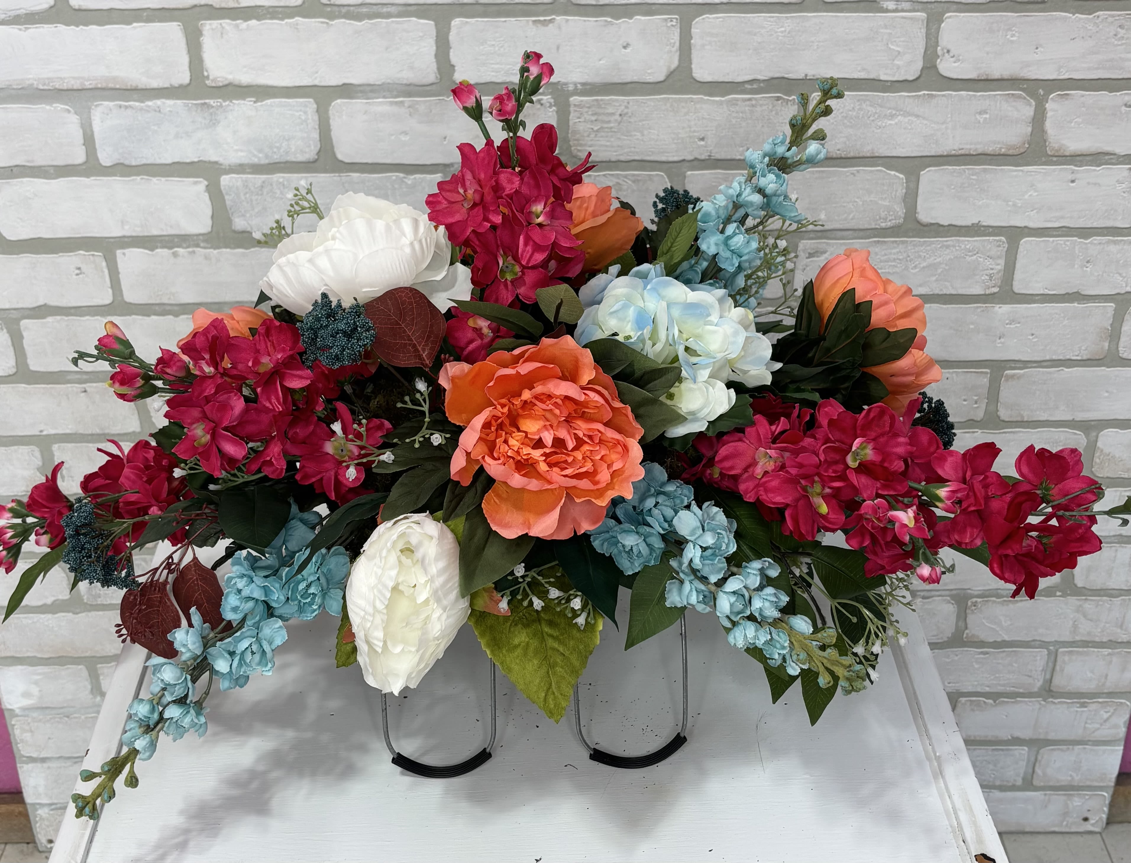 Bright mixed floral arrangement with pink, blue, white, and orange blooms