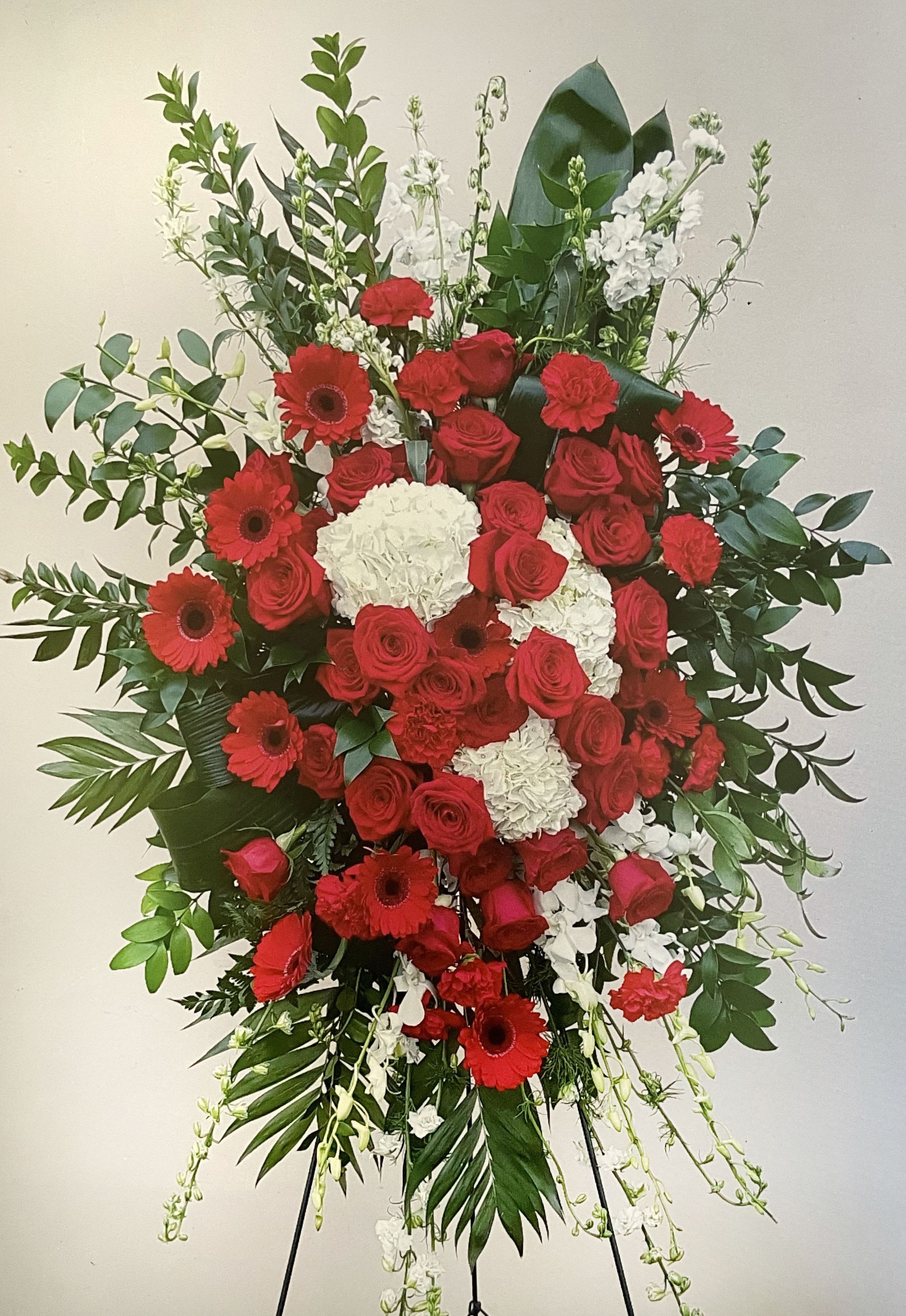 Large standing floral spray with red roses, red gerbera daisies, and white blooms