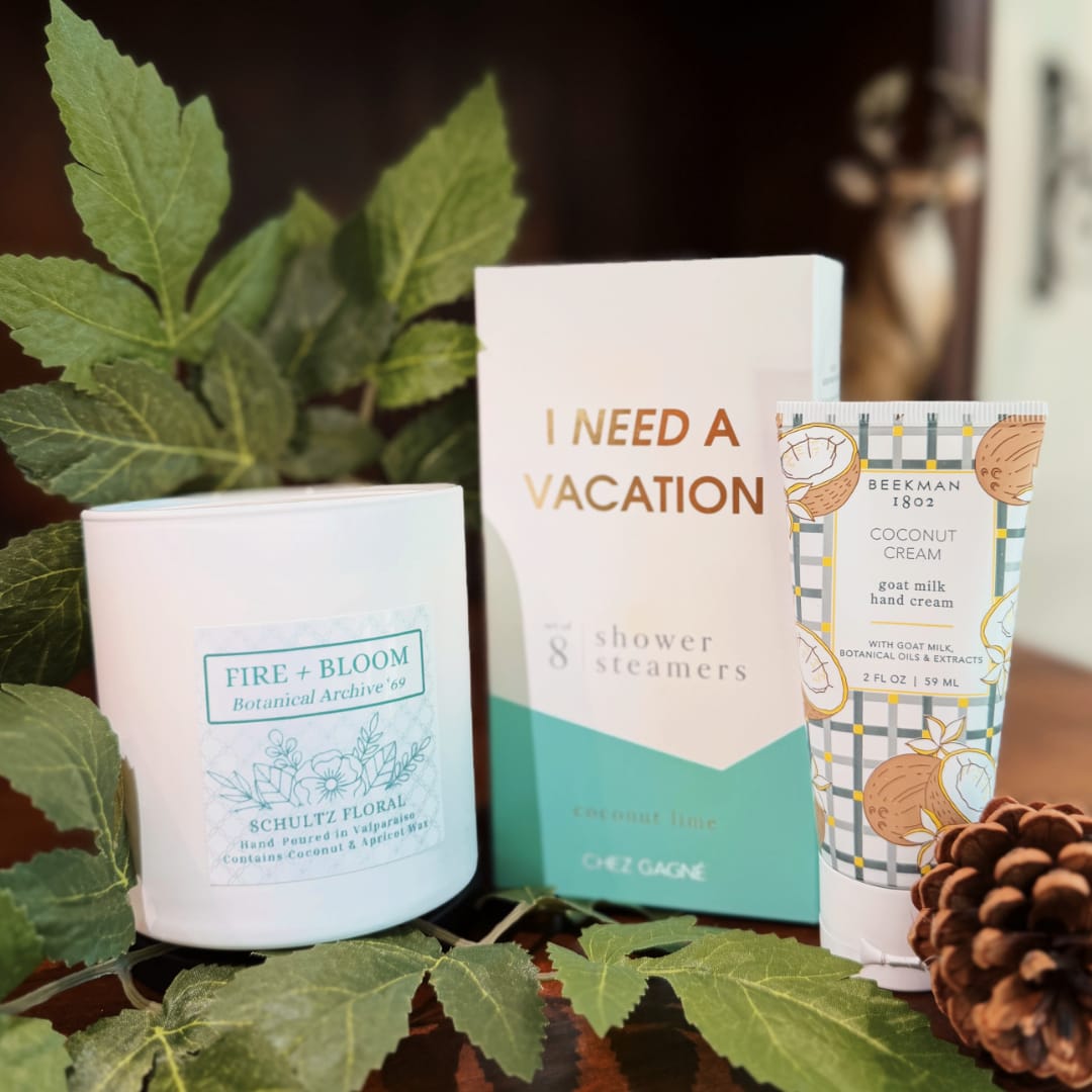 Gift set with a candle, shower steamers box, and hand cream tube
