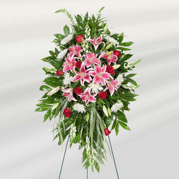 Standing floral spray with pink lilies, red roses, and white flowers