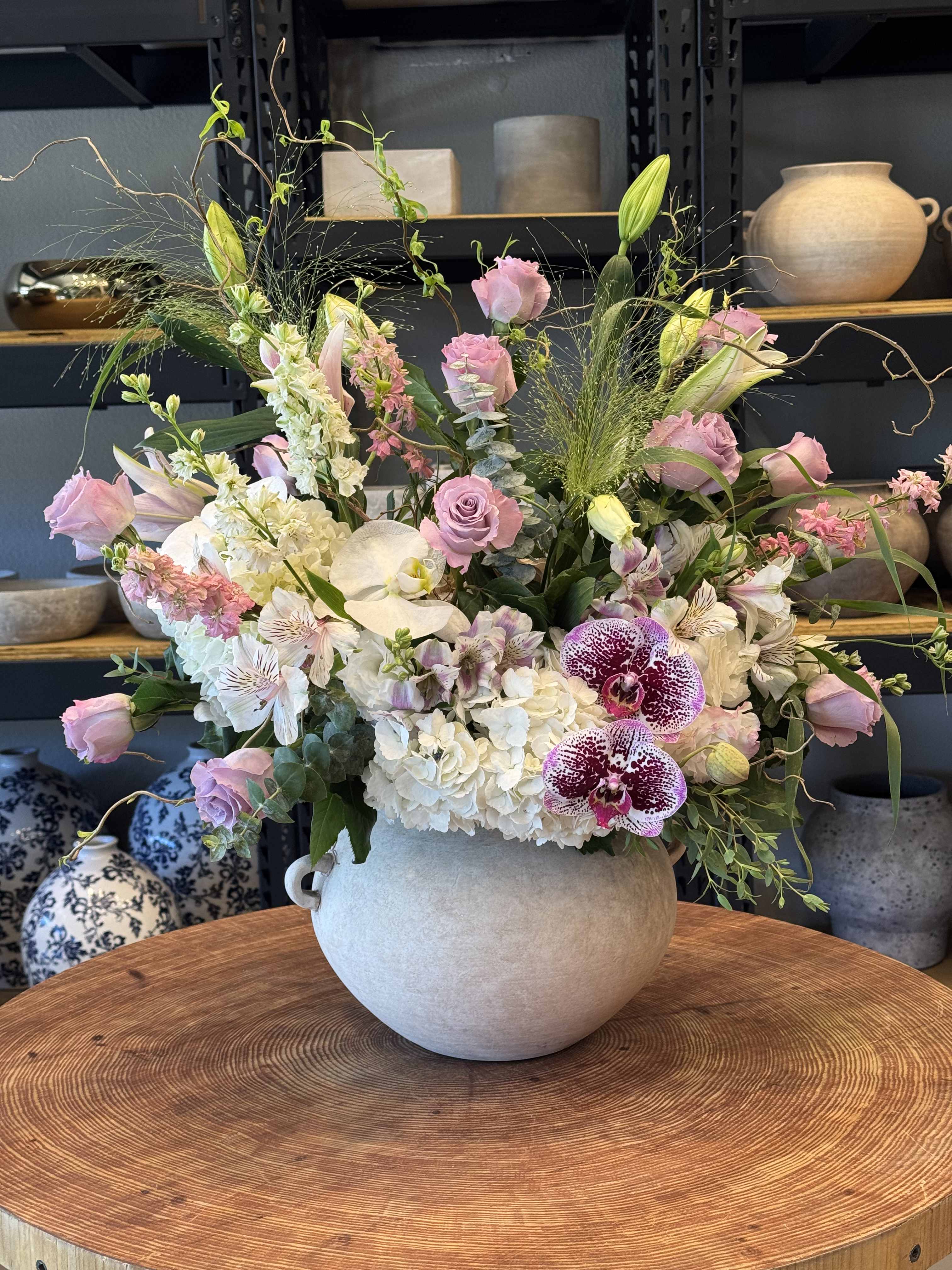 Large pastel flower arrangement in a round ceramic vase