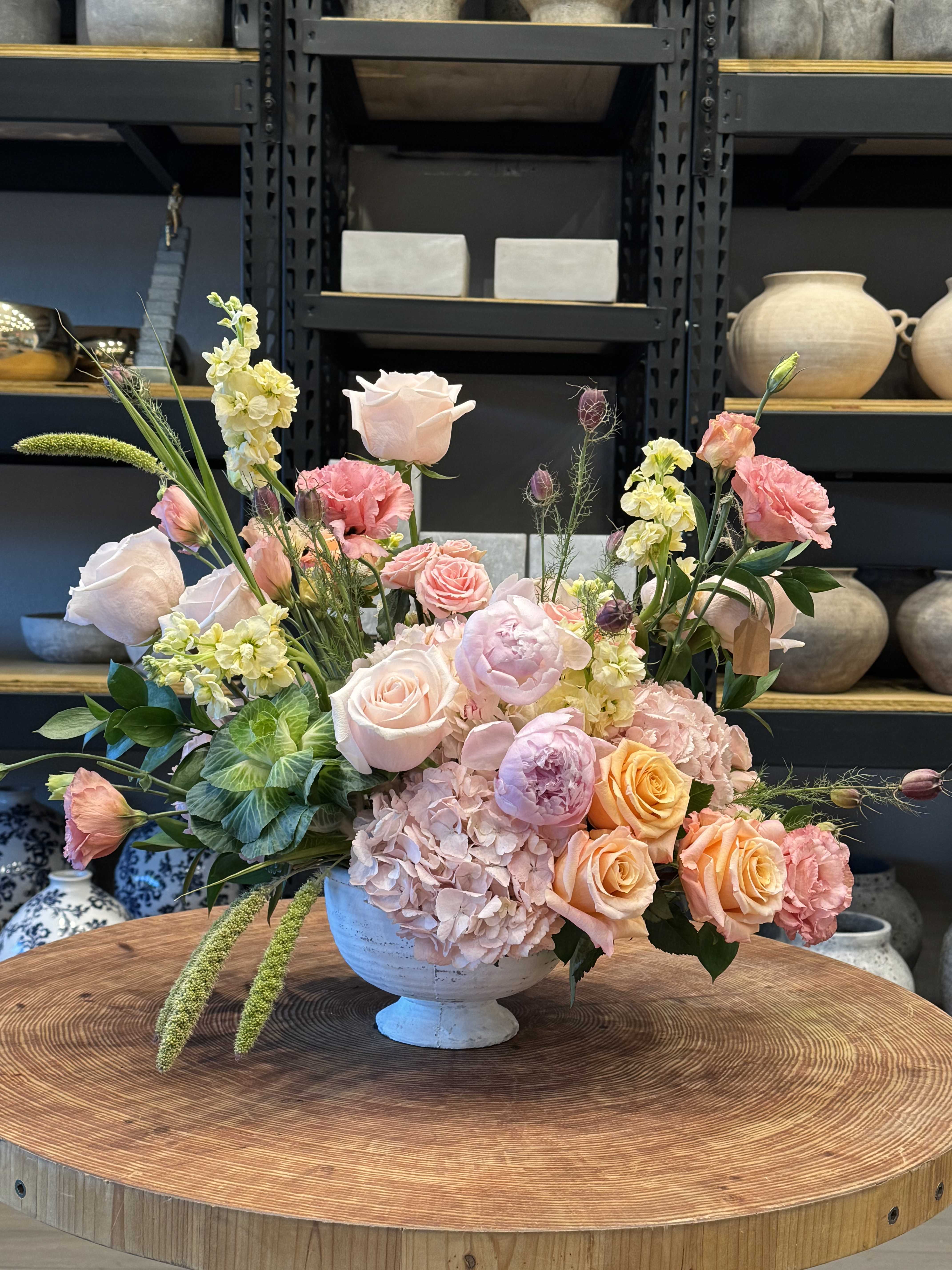 Pastel floral arrangement in a white pedestal vase