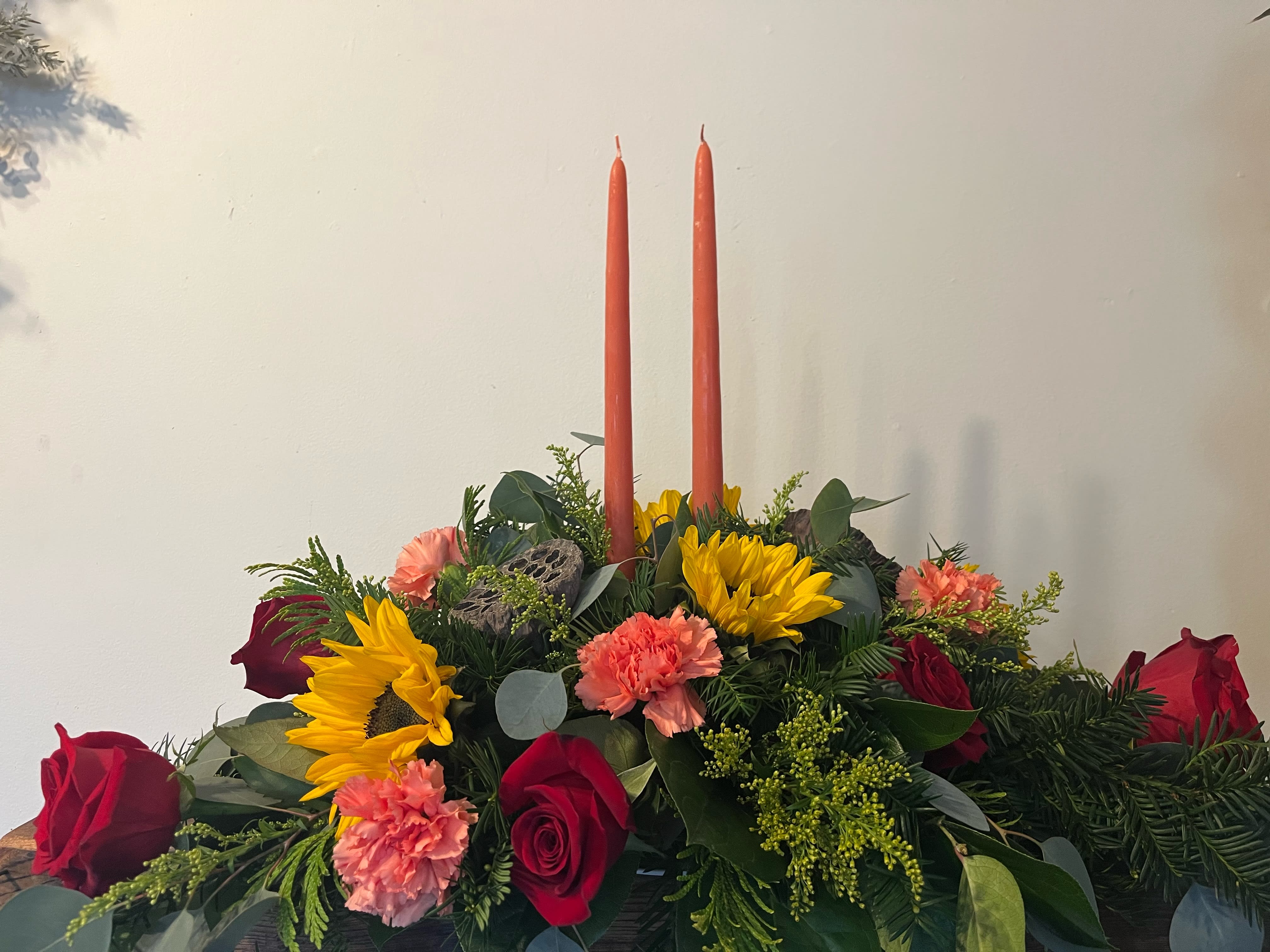 Thanksgiving Centerpiece Deluxe - A mixture of fall flowers, with candle to adorn your thanksgiving table. Please call to place centerpiece orders to ensure proper dimensions. 