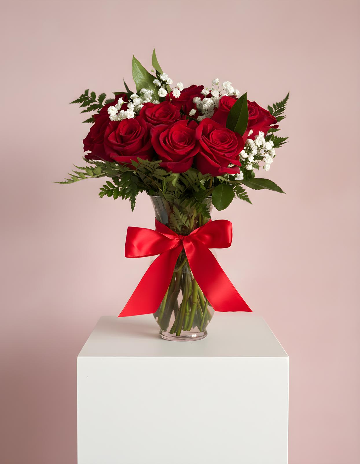 Red roses in a glass vase with a red ribbon