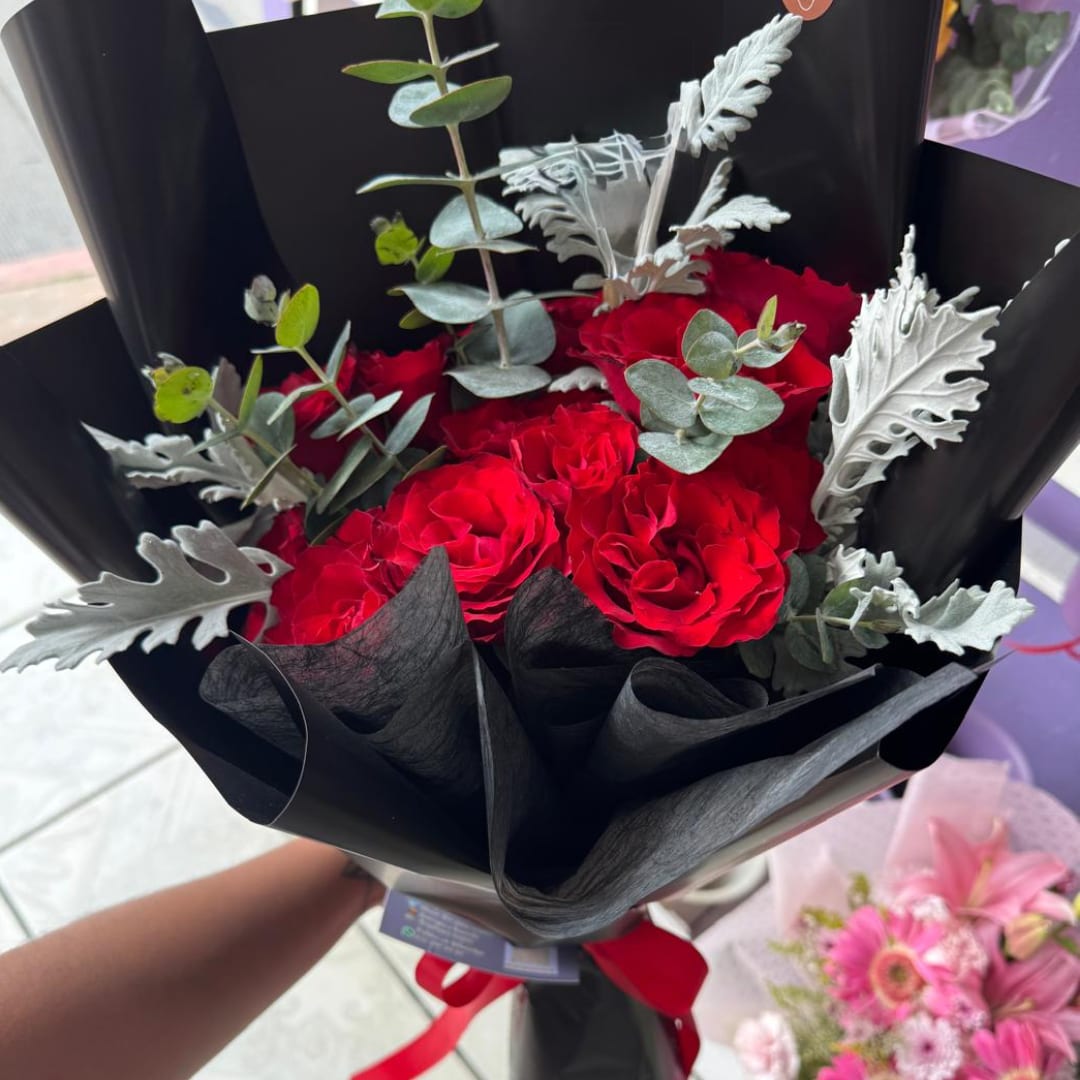 Red rose bouquet wrapped in black paper with silver foliage