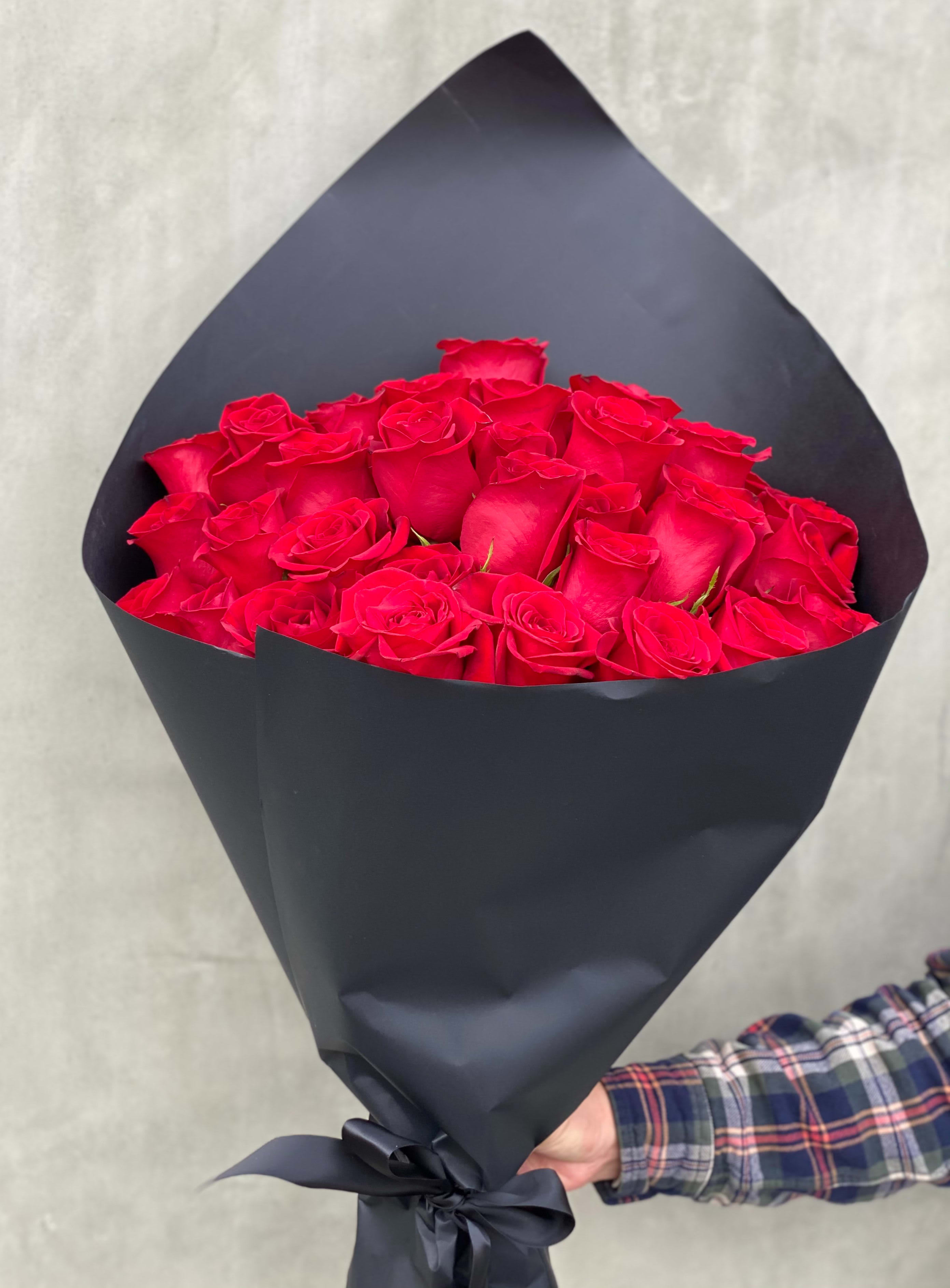 Bouquet of red roses wrapped in black paper