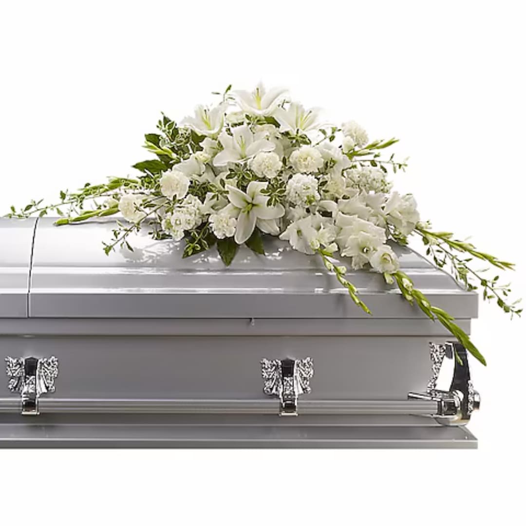 White floral spray on a silver casket