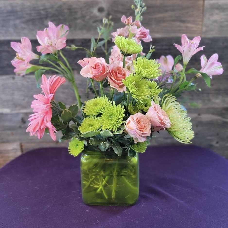 Pink and green mixed bouquet in a square glass vase