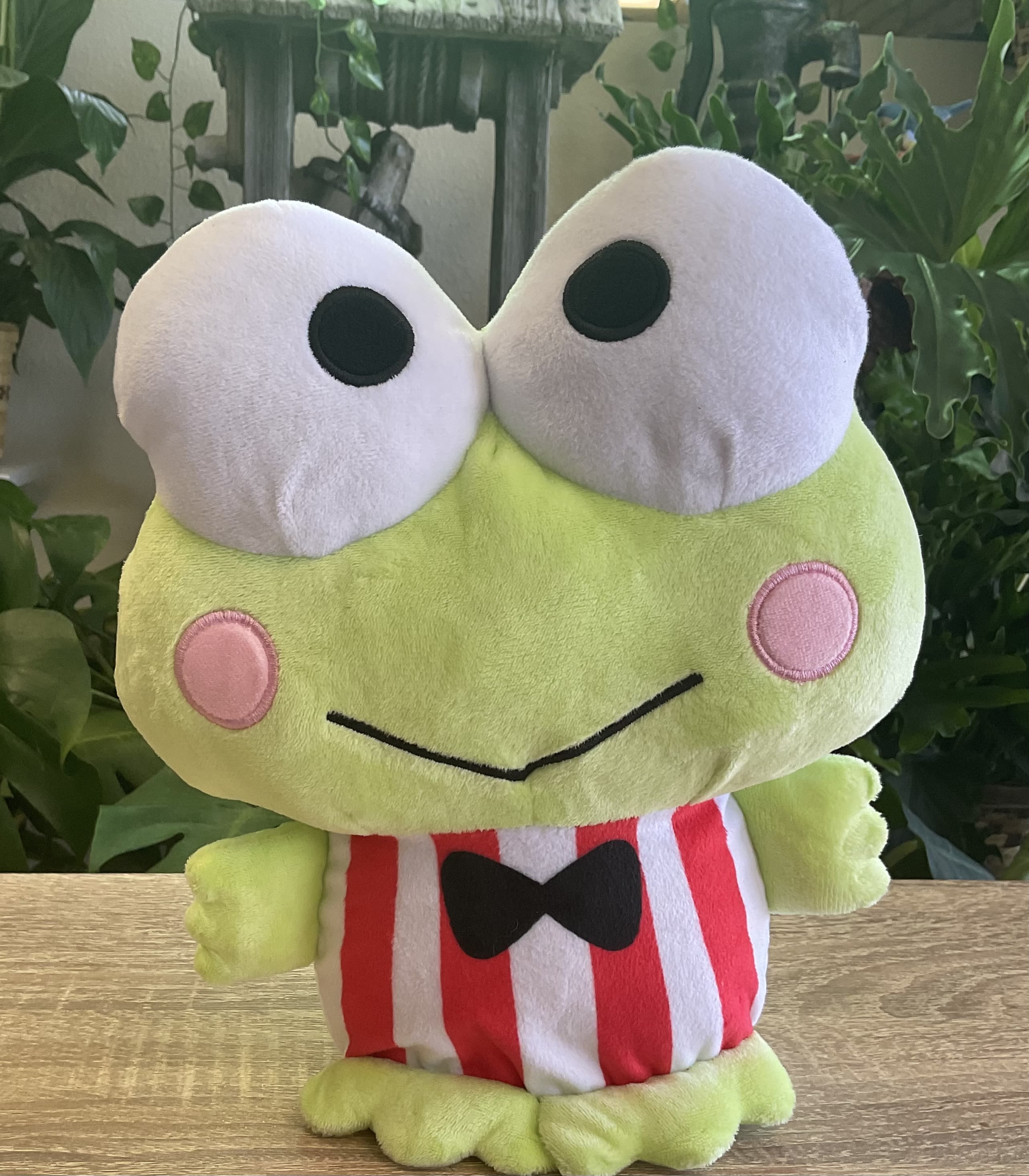Plush frog toy with a red-and-white striped outfit and bow tie