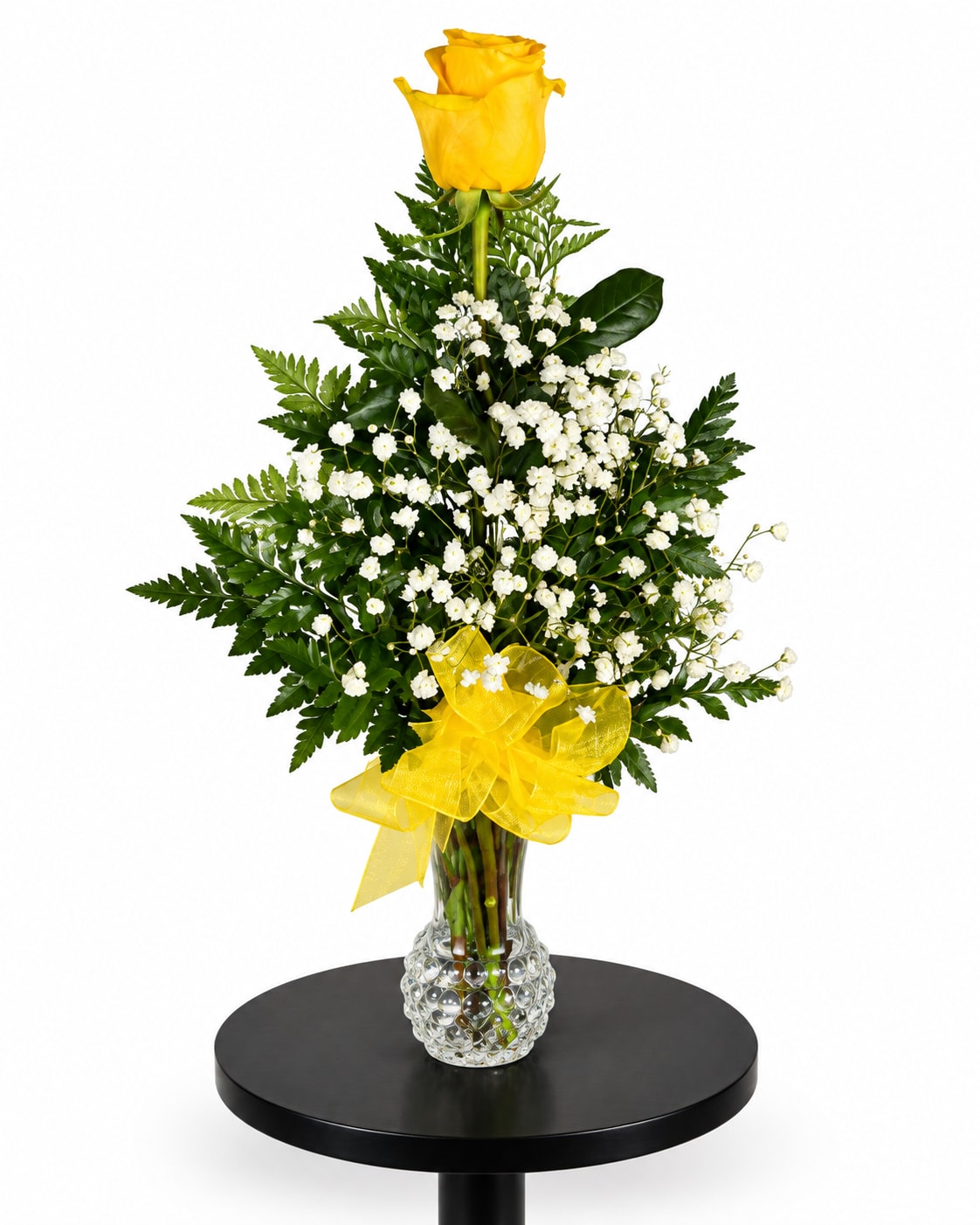 Yellow roses with white baby's breath in a clear vase with a yellow bow