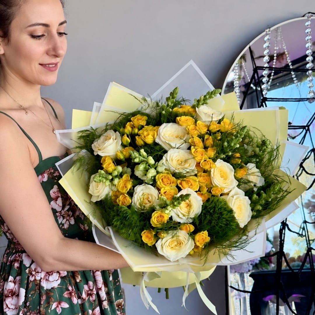 Woman holding a bouquet of white and yellow roses