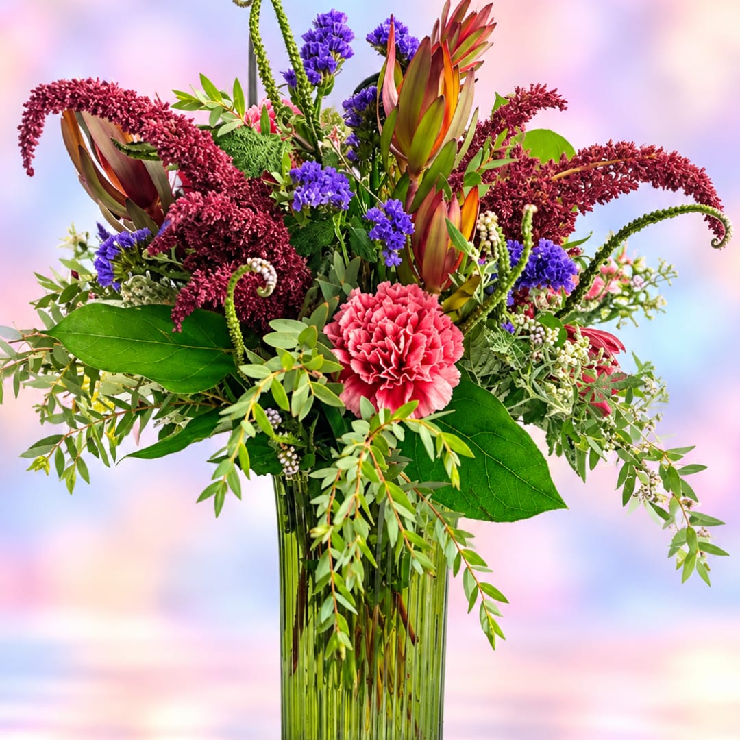 Colorful mixed bouquet in a tall glass vase