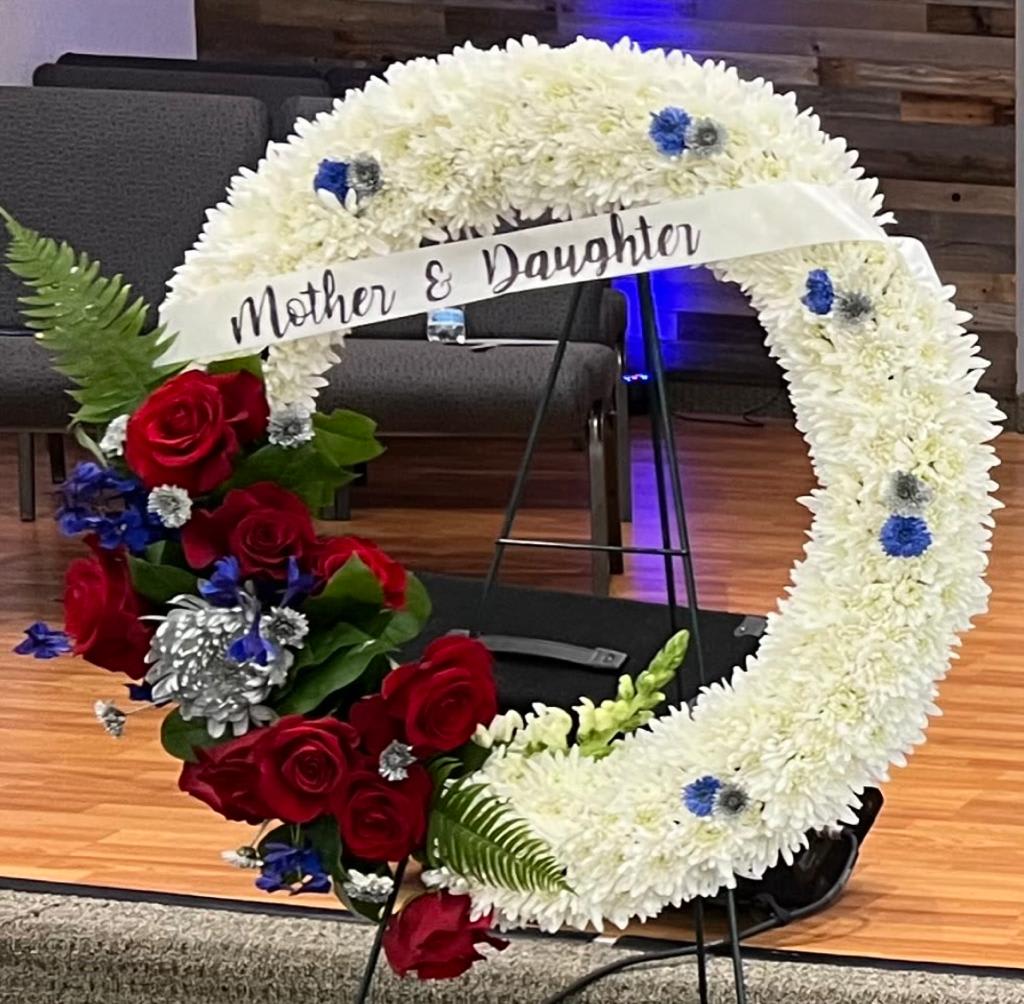 Heart-shaped floral tribute with white chrysanthemums and red roses