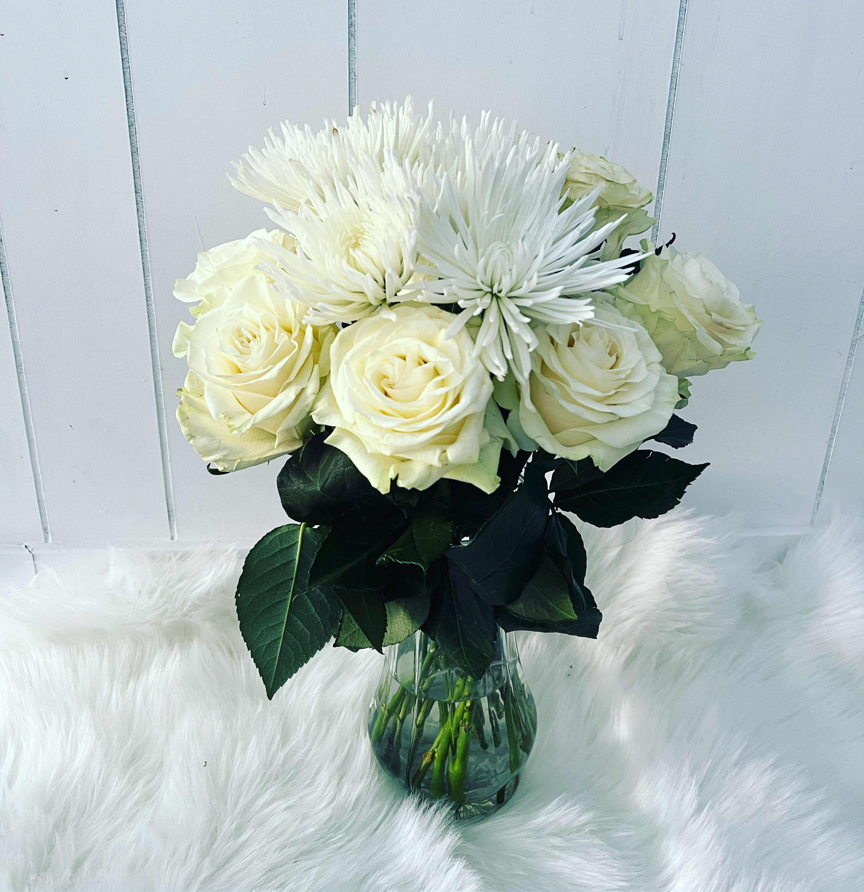 White roses and spider mums in a glass vase