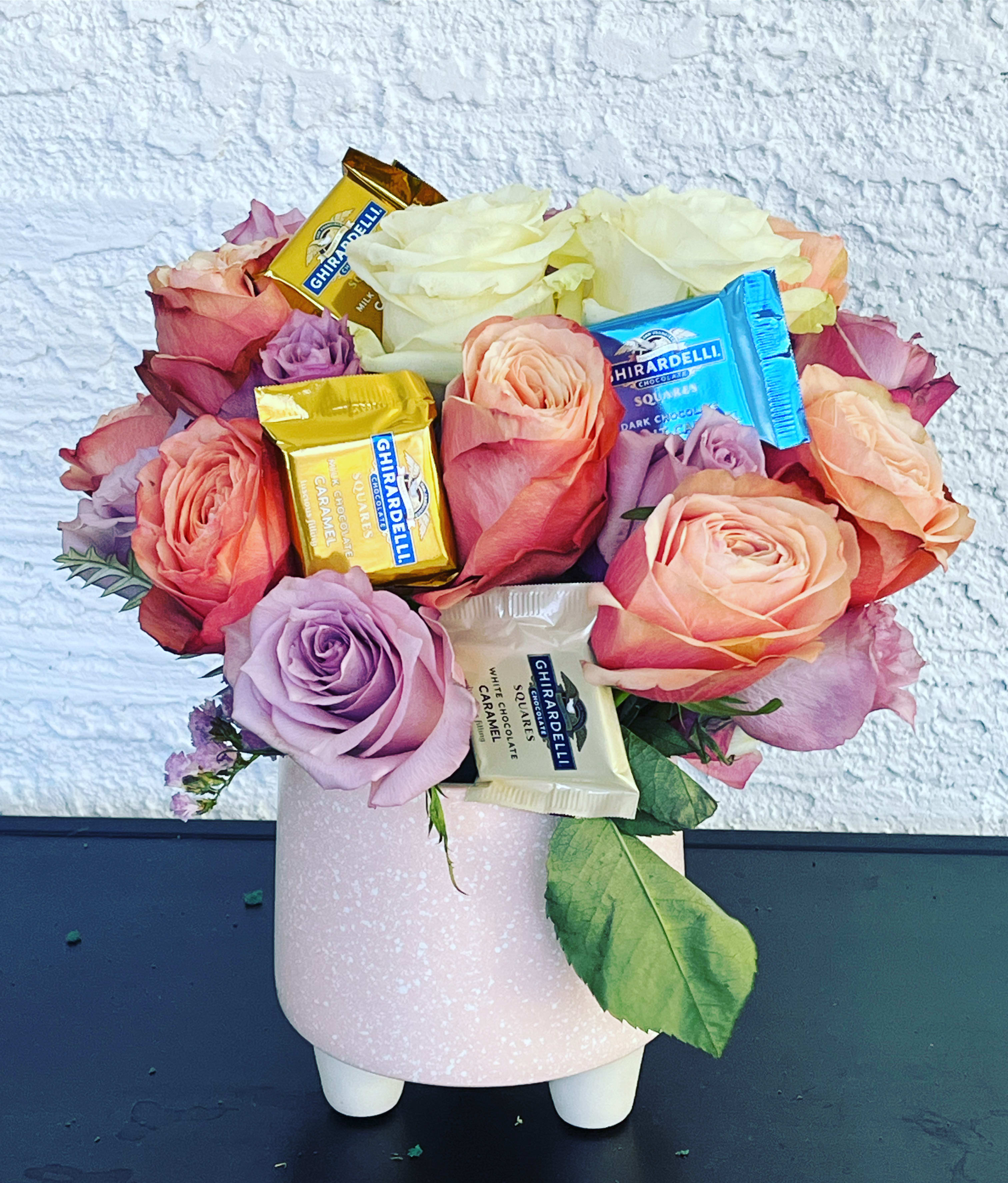 Pink and peach roses with Ghirardelli chocolates in a pink vase