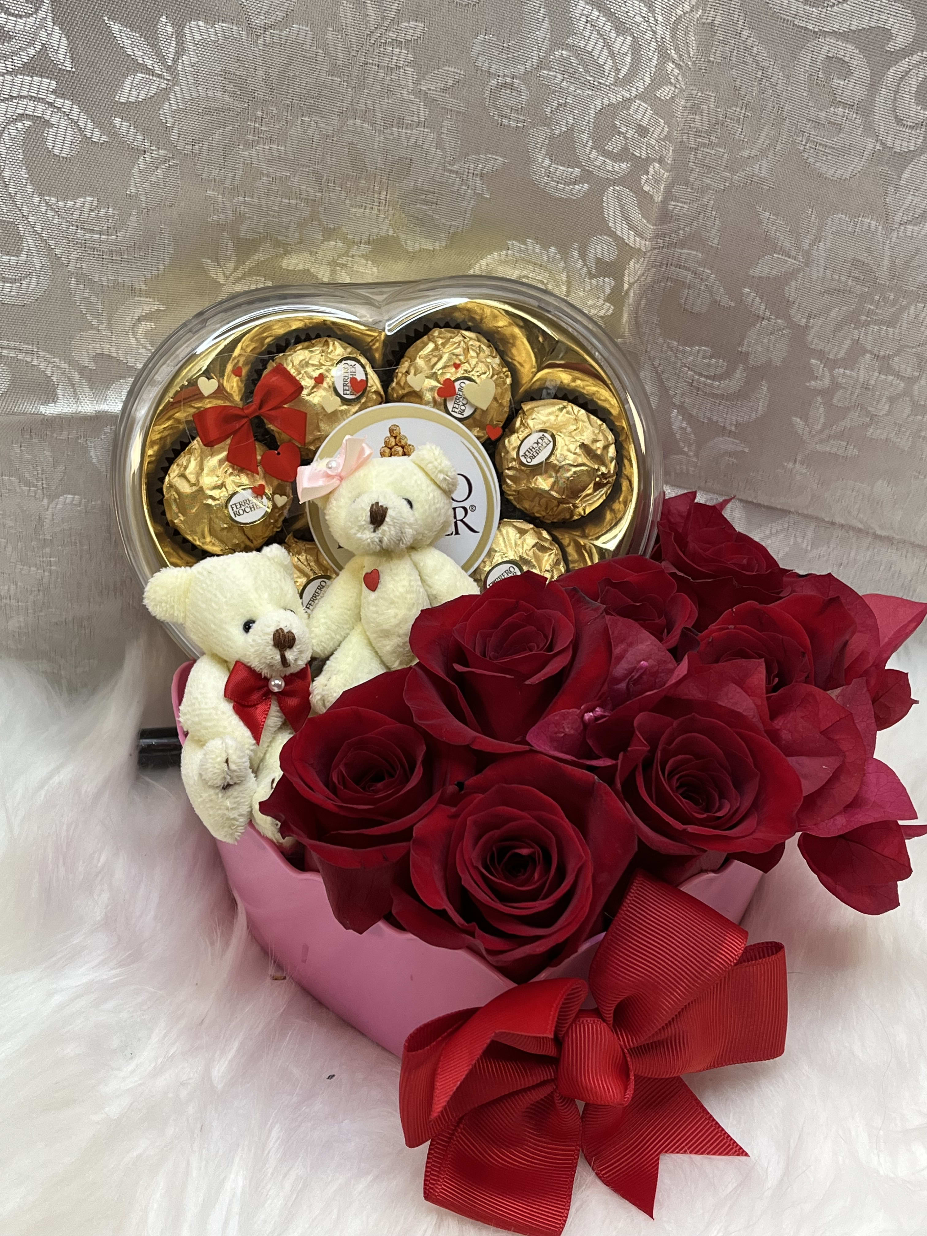 Red roses with teddy bears and chocolate candies in a heart-shaped box