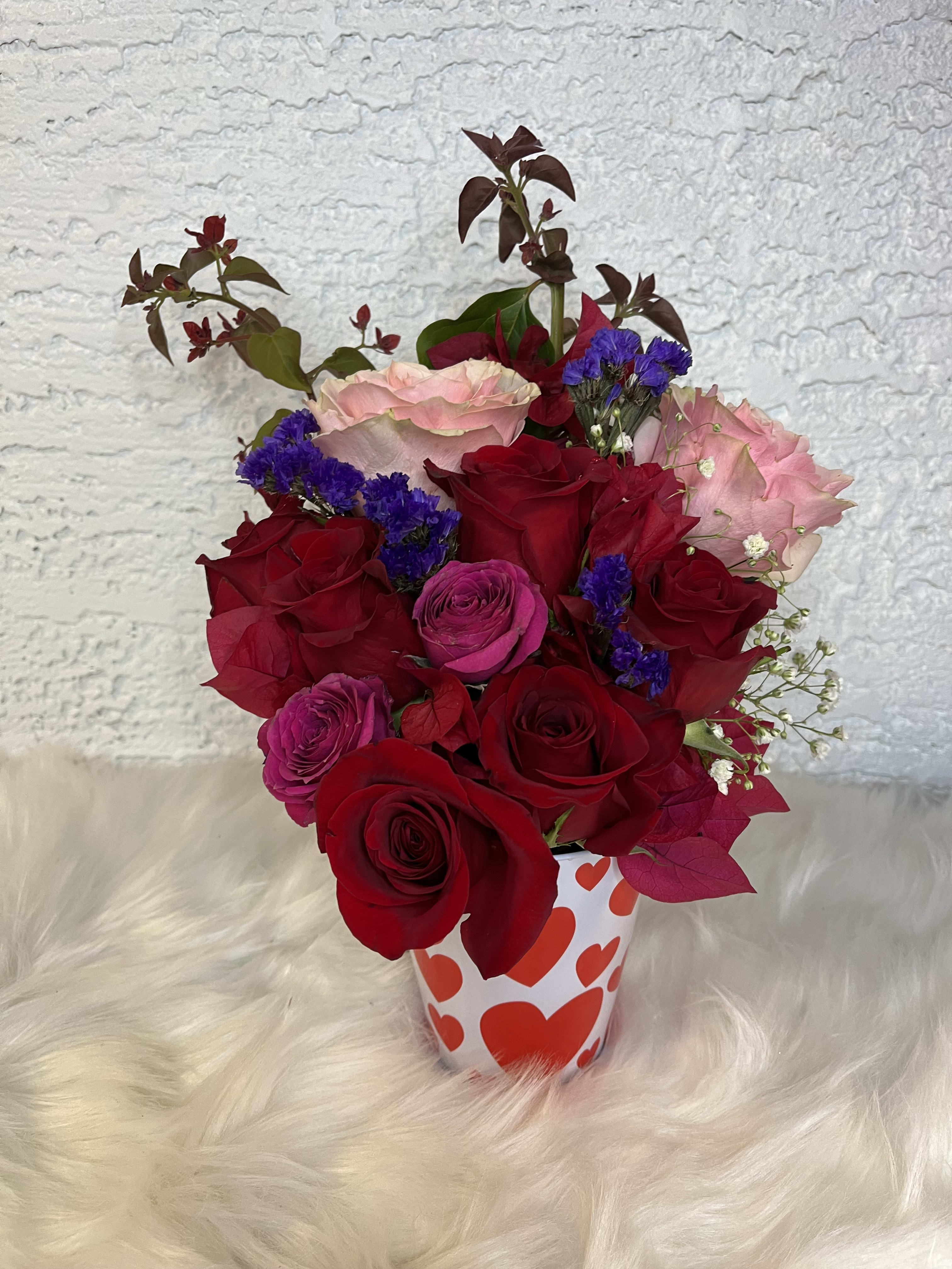 Bouquet of red and pink roses in a heart-patterned cup