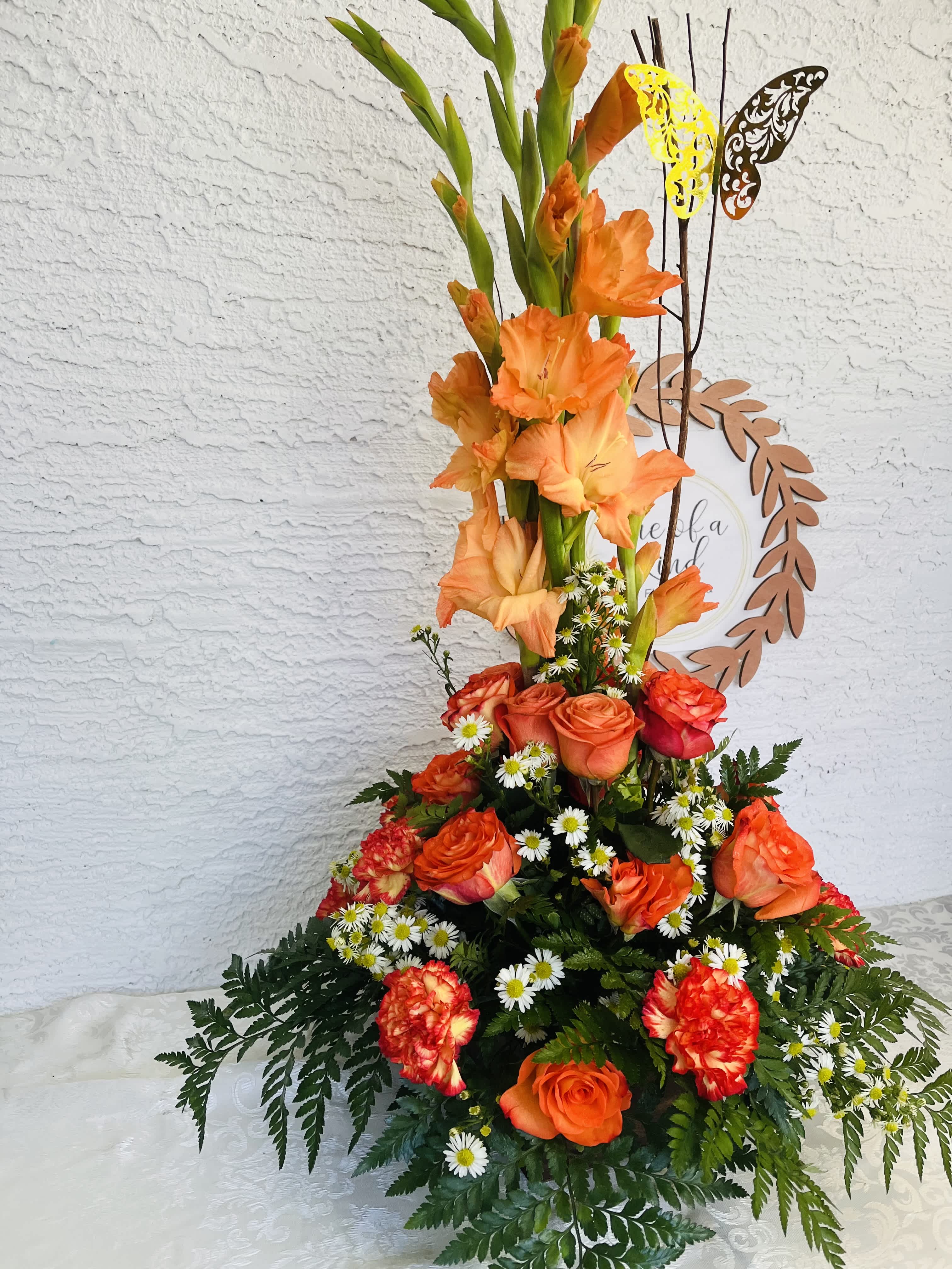 Tall orange floral arrangement with roses and gladiolus