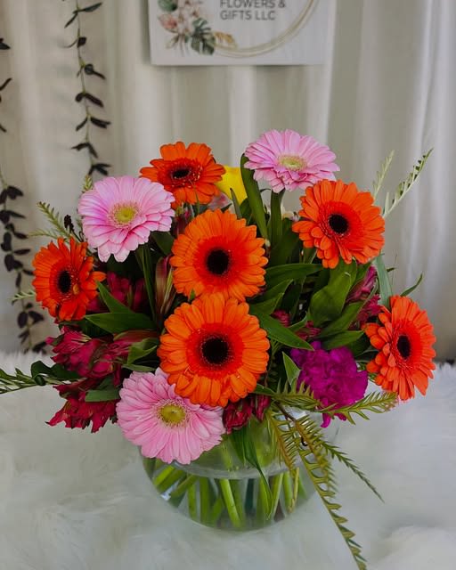 Good Morning - Bright &amp; Cheerful Gerbera Arrangement This vibrant arrangement bursts with color and joy! Featuring a lively mix of orange, pink, and red gerbera daisies complemented by fresh greenery and accent blooms, it’s the perfect centerpiece to brighten any room or celebrate a happy occasion.  Flowers: Gerbera daisies (orange, pink, and red)  Customization available to match your color preference.  Approximate Dimensions: 10"D x 10"H