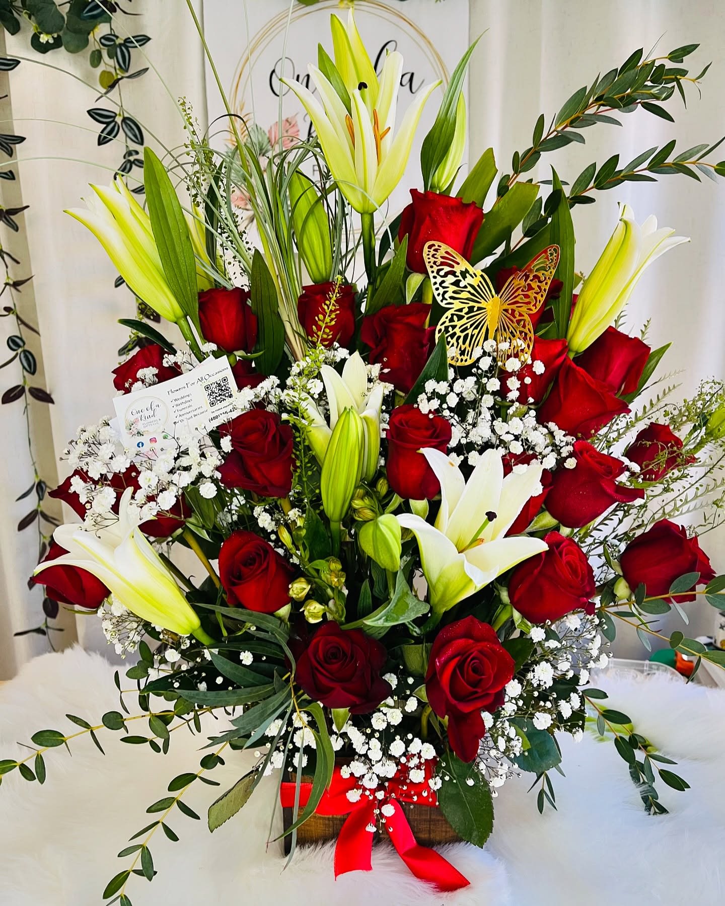 Red roses and white lilies in a basket with baby's breath