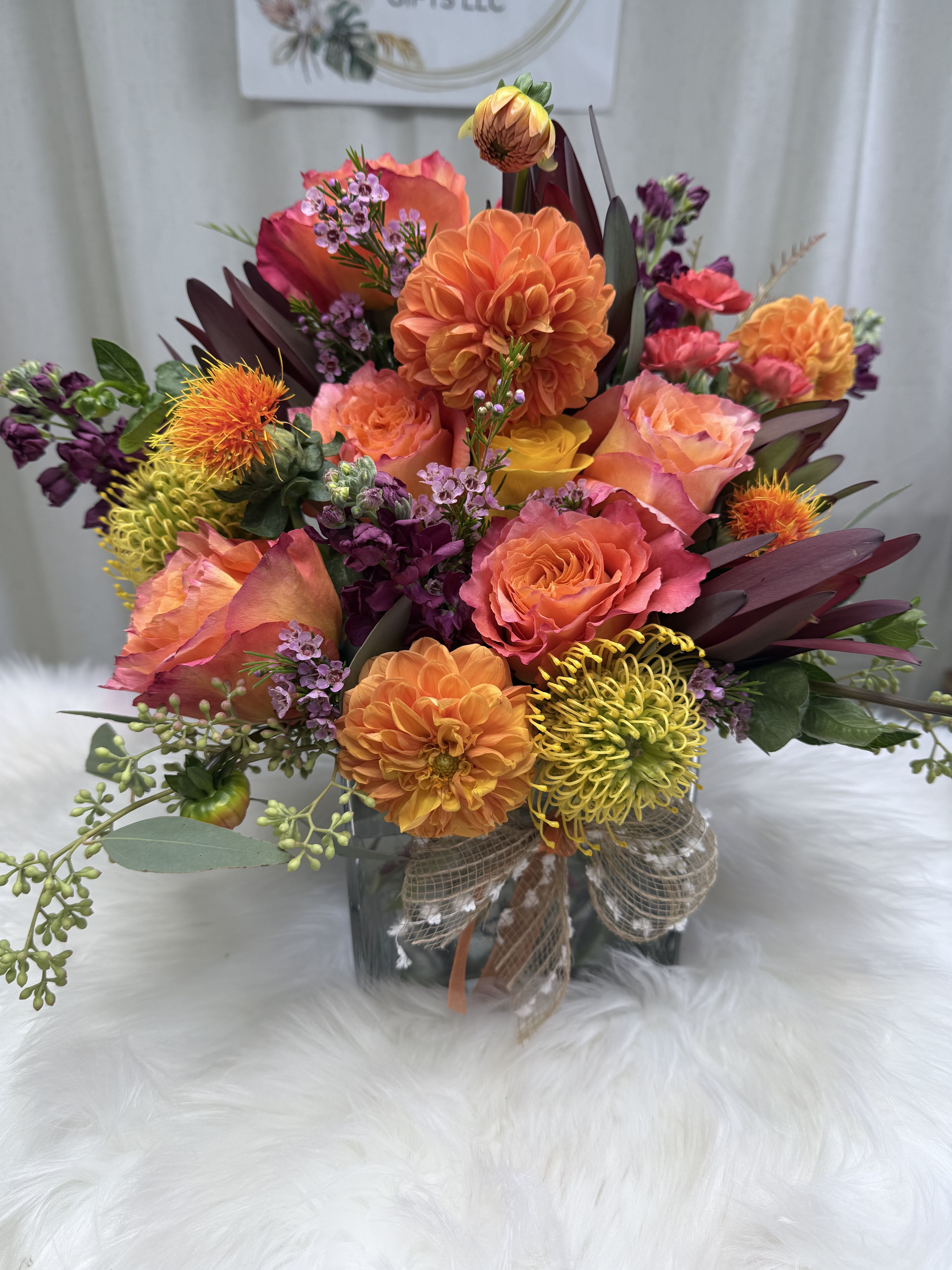 Bright mixed bouquet in a glass vase with orange, pink, and yellow blooms