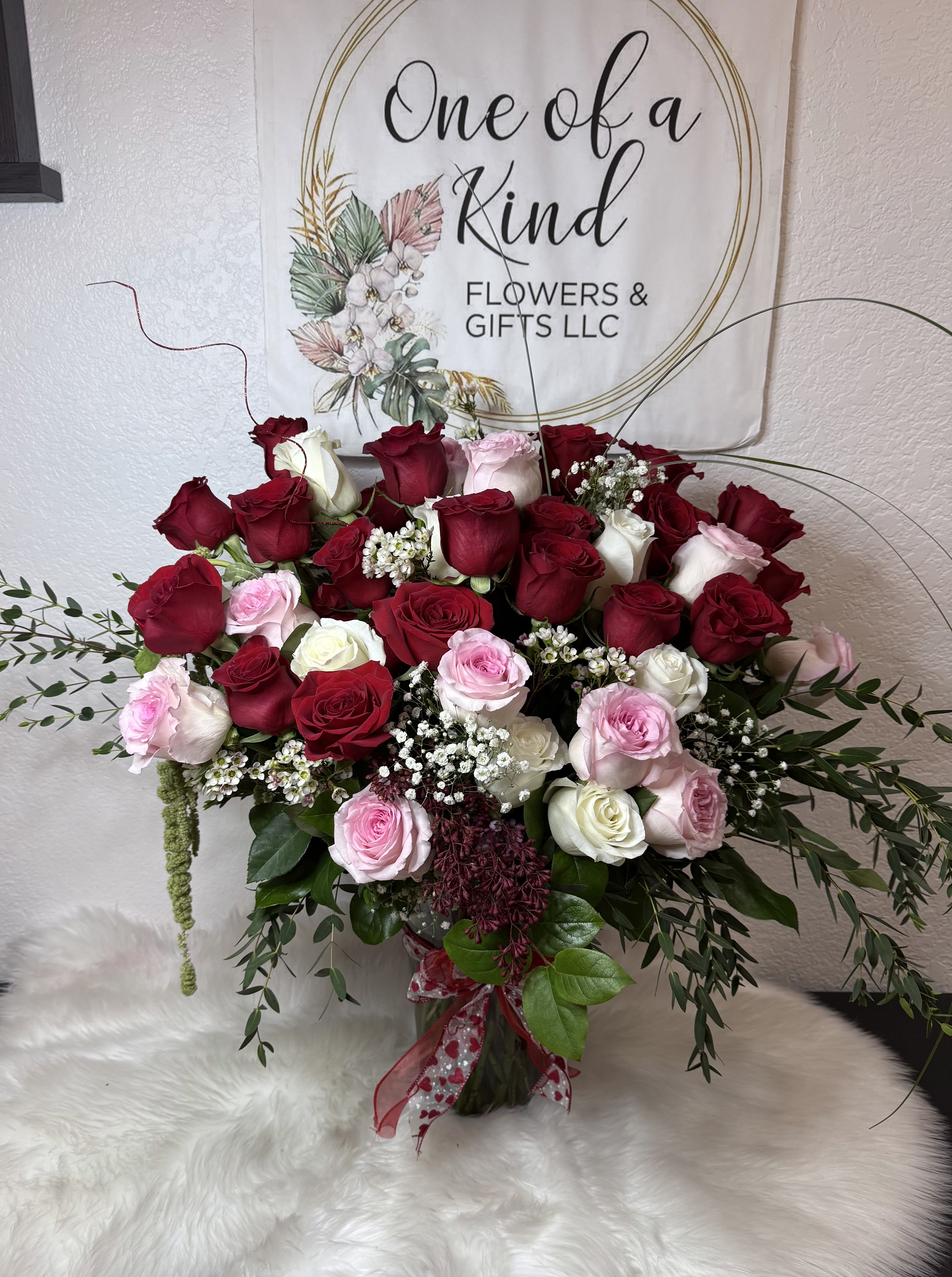 Large bouquet of red, pink, and white roses with baby's breath