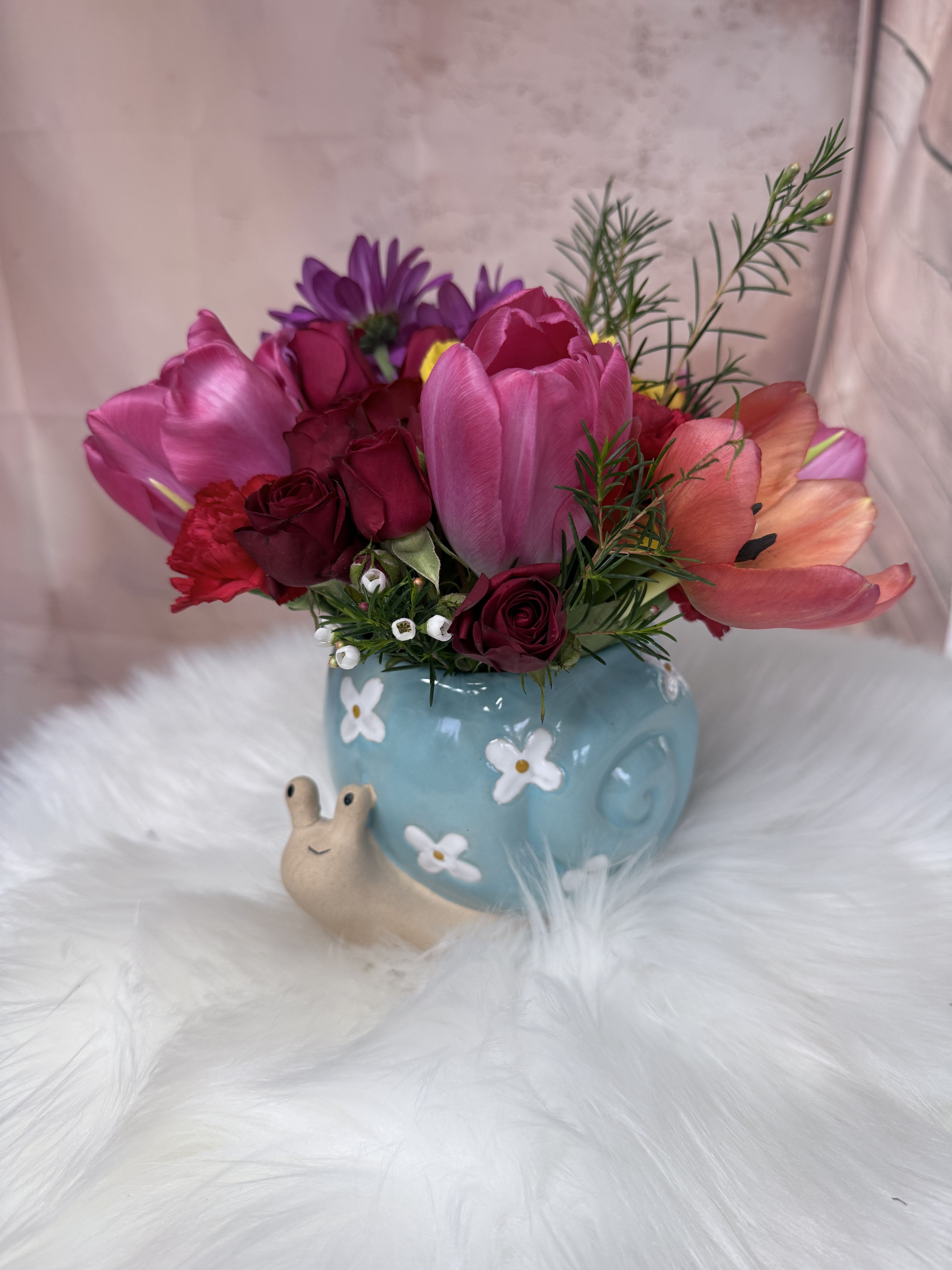Turbo - A sweet and charming arrangement featuring delicate flowers and fresh seasonal foliage in an adorable snail-shaped cup.