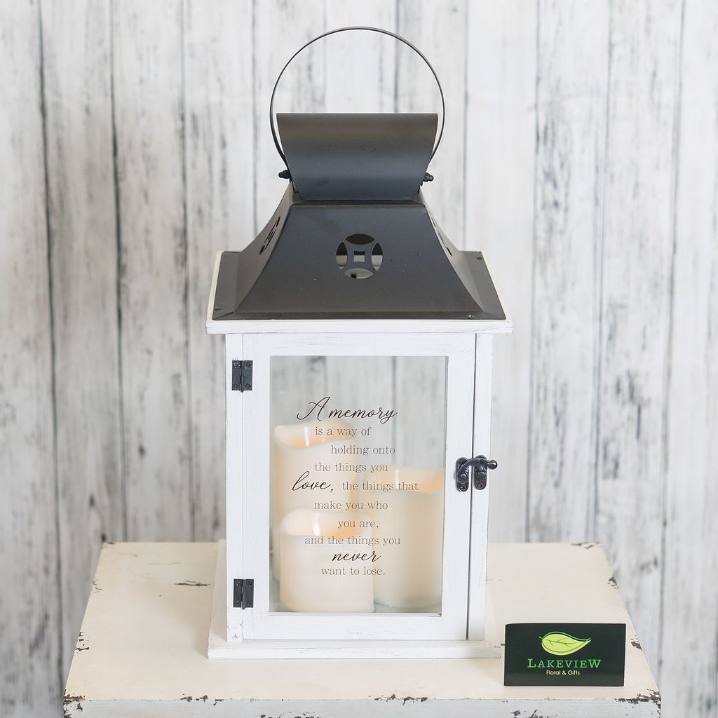 White lantern with candles and a memory quote