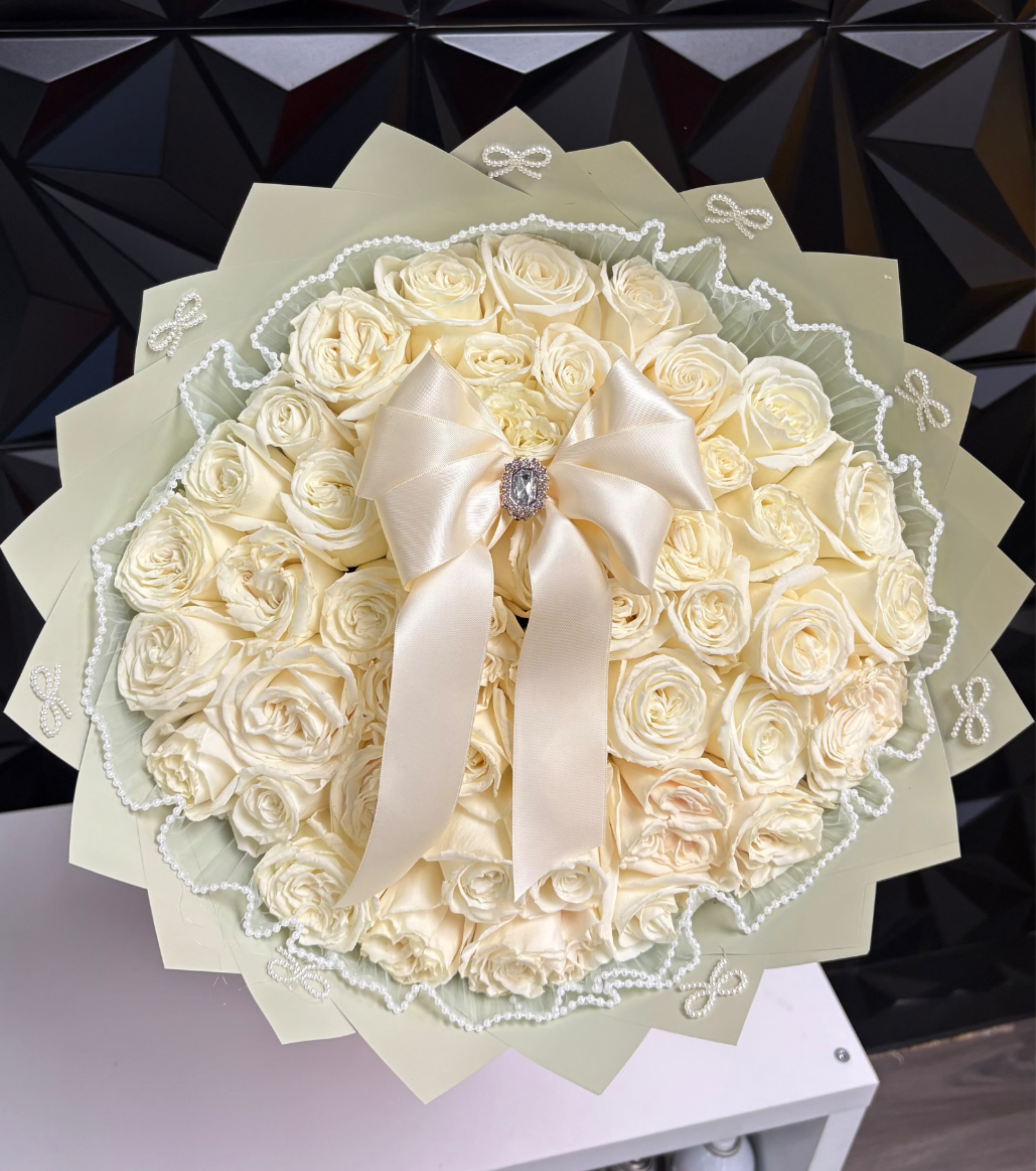 Cream rose bouquet with a satin bow and pearl trim