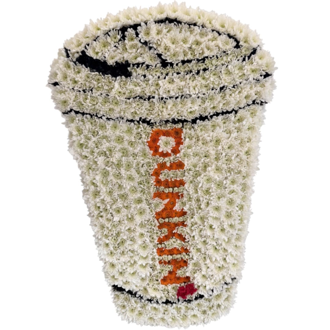 White floral funeral wreath with orange lettering and black accents