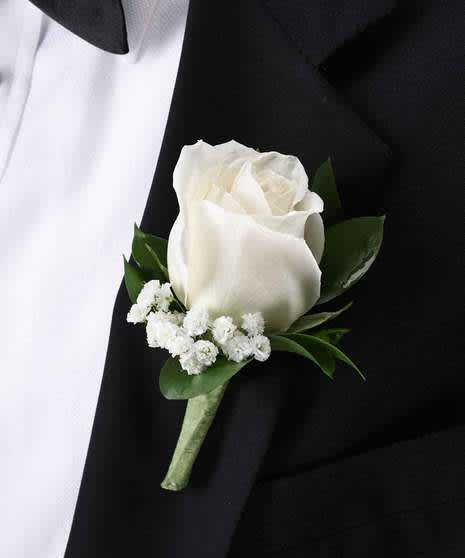 White rose boutonniere with small white filler flowers on a black suit lapel