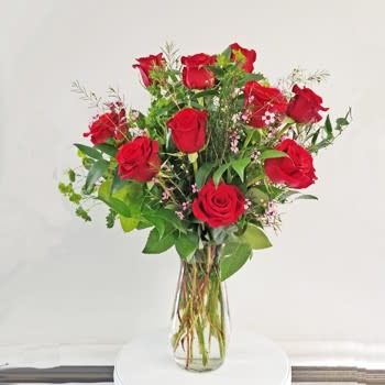 Red roses arranged in a clear glass vase