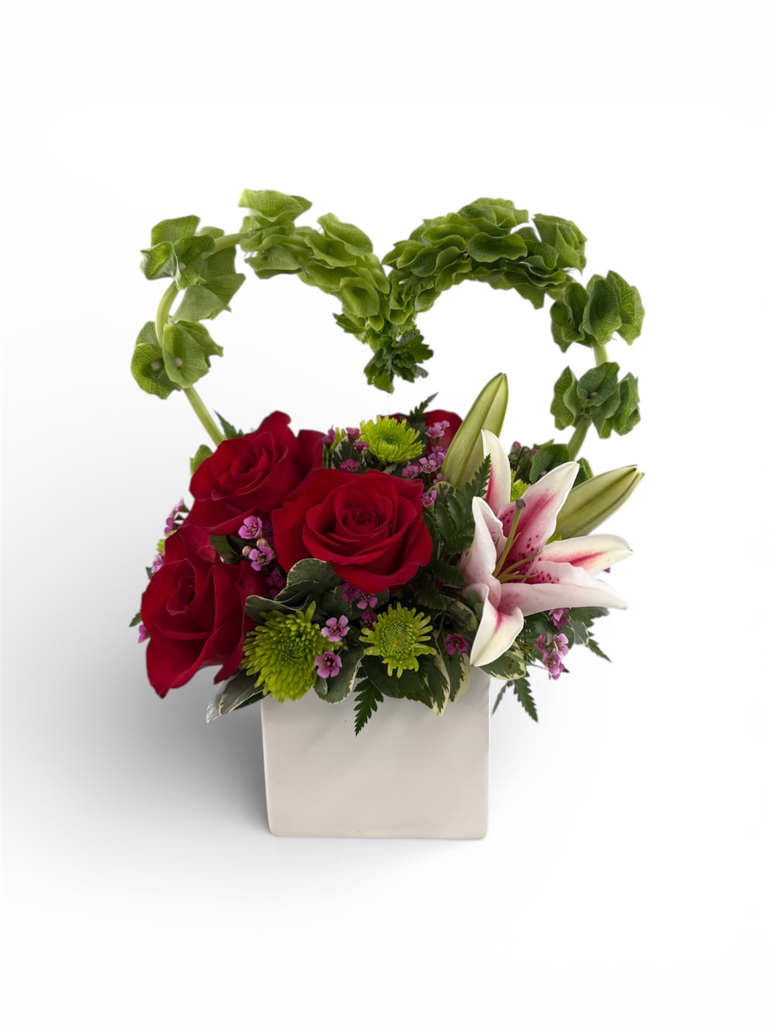 Red roses and white lilies in a white square vase with a green heart handle