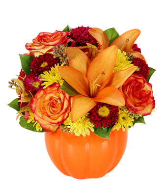Orange lilies and roses in a pumpkin-shaped vase