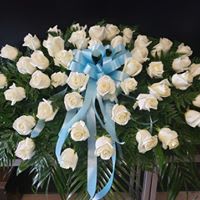 White rose wreath with a blue ribbon bow