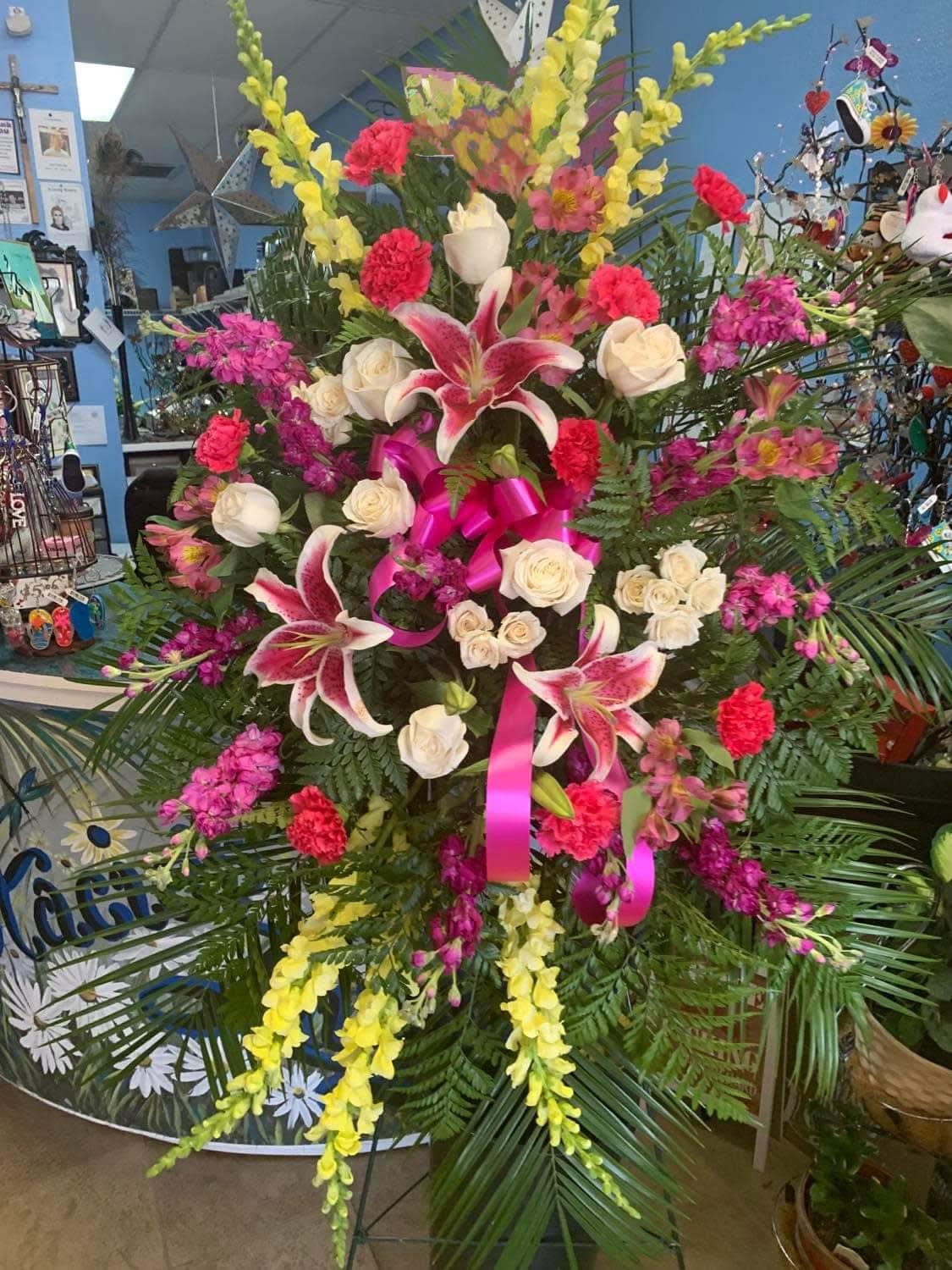 Large standing floral spray with pink lilies, white roses, and yellow blooms